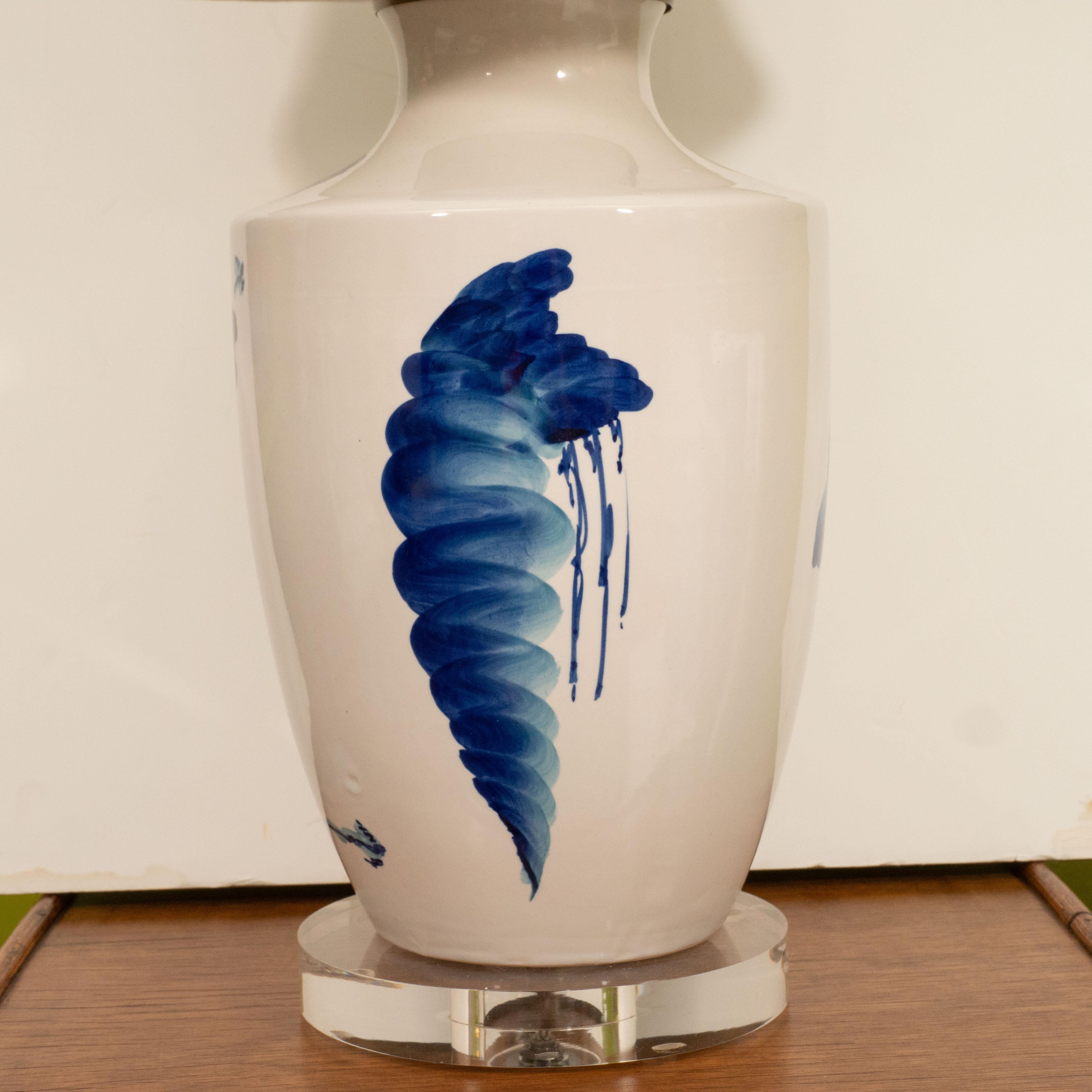 Blue and white will never go out of style. This pair features an Asian inspired blue design on a white background, with linen shades on a Lucite base.