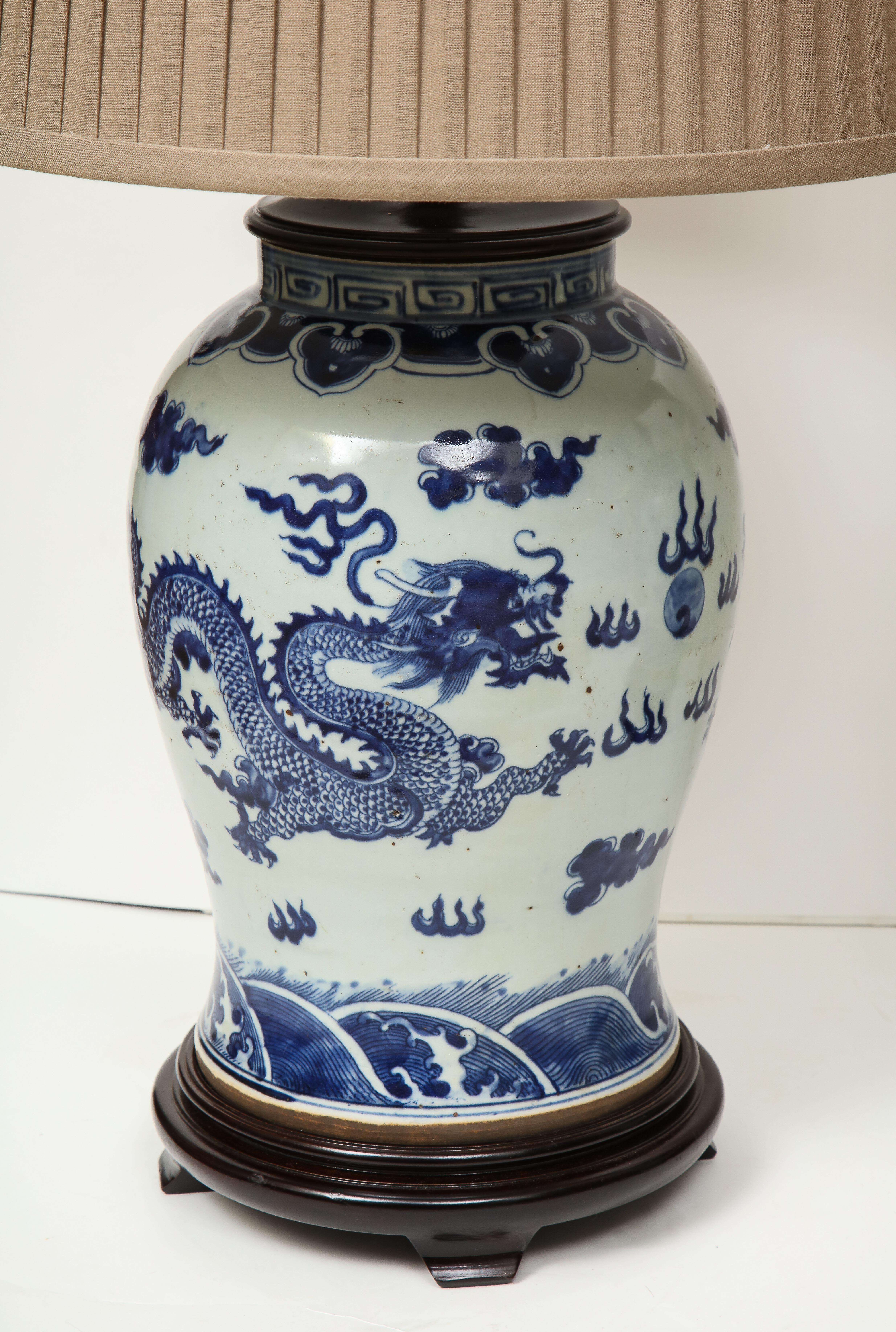 Blue and white will never go out of style. This nice looking pair of Chinese export porcelain jars have been made into lamps on a wood base with taupe pleated shades. A great way to add color and personality to a space, these would look great on