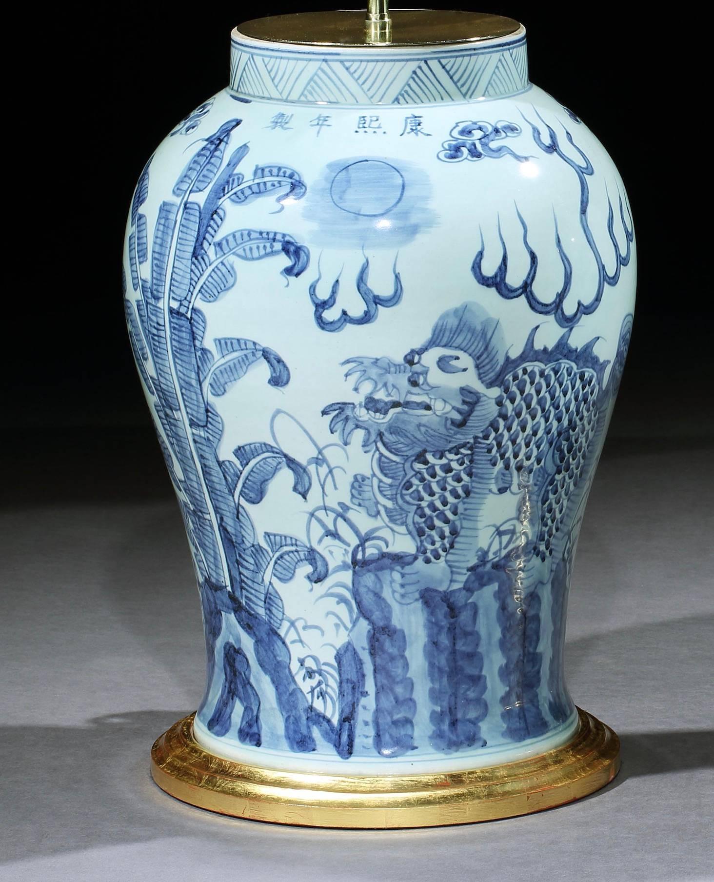 A charming pair of Chinese blue and white vases of baluster form, decorated with foo dogs. Now mounted as lamps with hand-gilded turned bases.
 