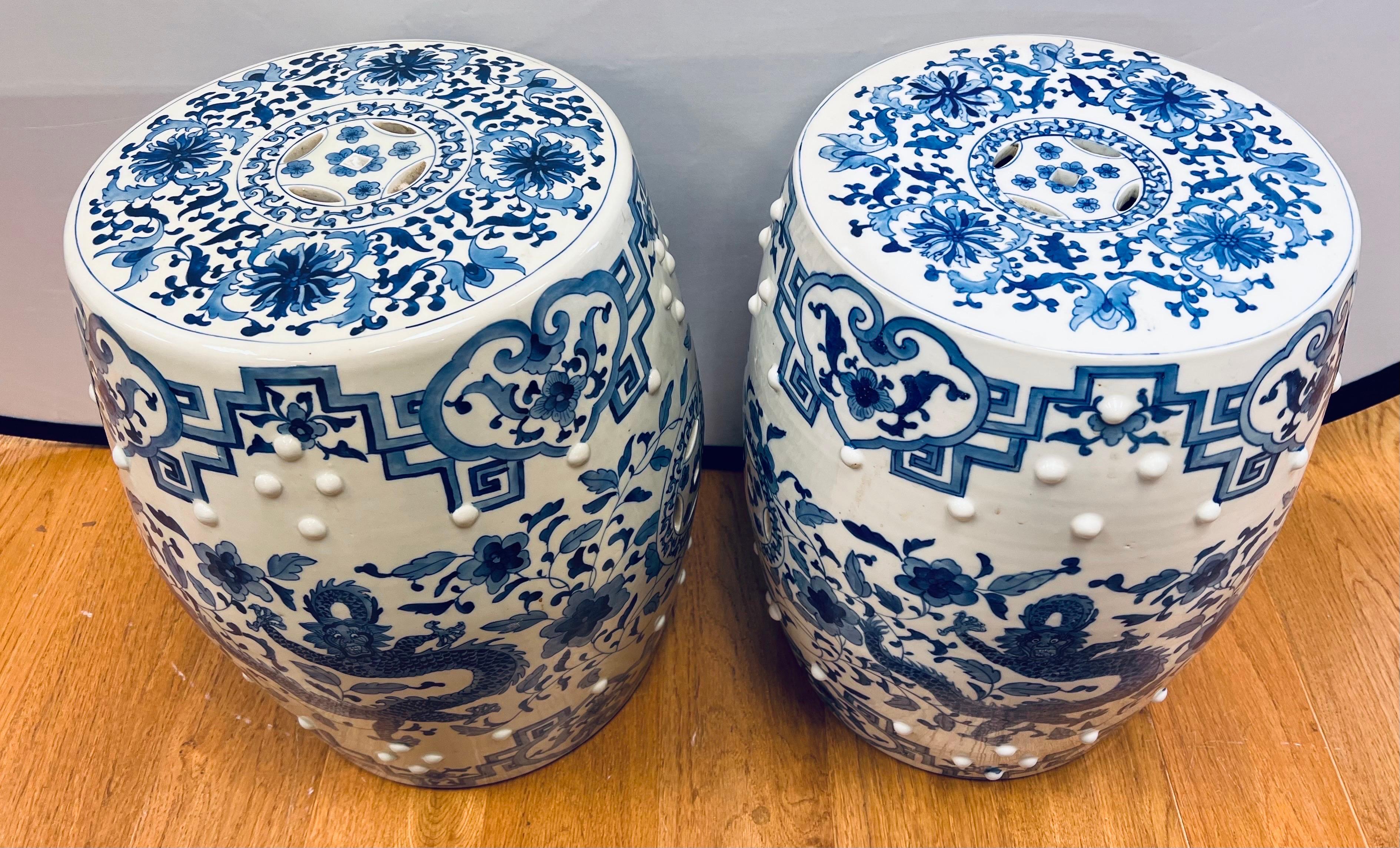 Magnificent pair of chinoiserie porcelain blue and white garden stools or end tables with gorgeous intricate hand painted motifs of dragons and flowers. Pierced detail on the top and sides.