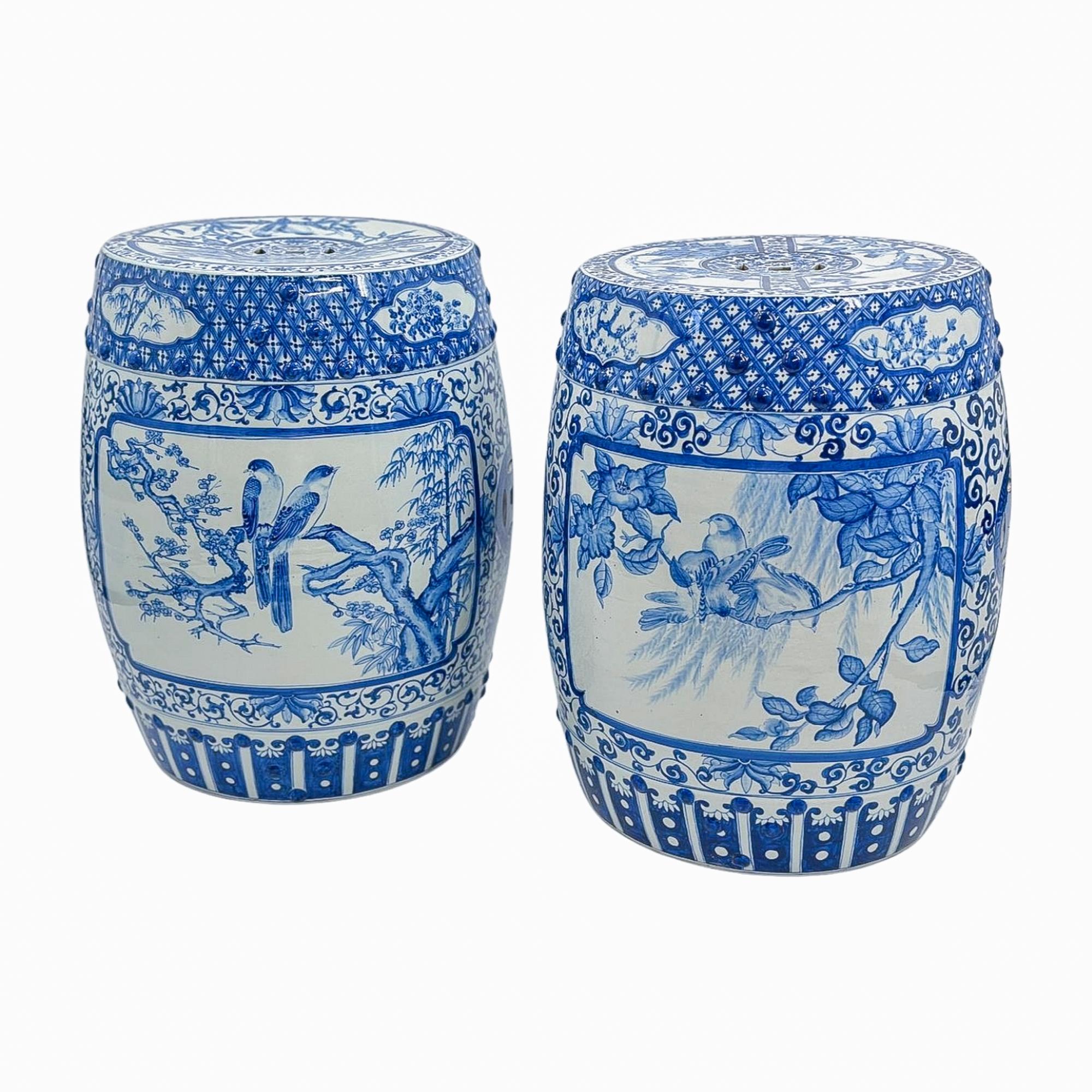An elegant pair of blue-and-white porcelain garden stools, each finely hand-painted with continuous bird-and-branch landscapes enclosed by classic trellis and fretwork borders. The cobalt decoration is rich in tone, layered with delicate shading