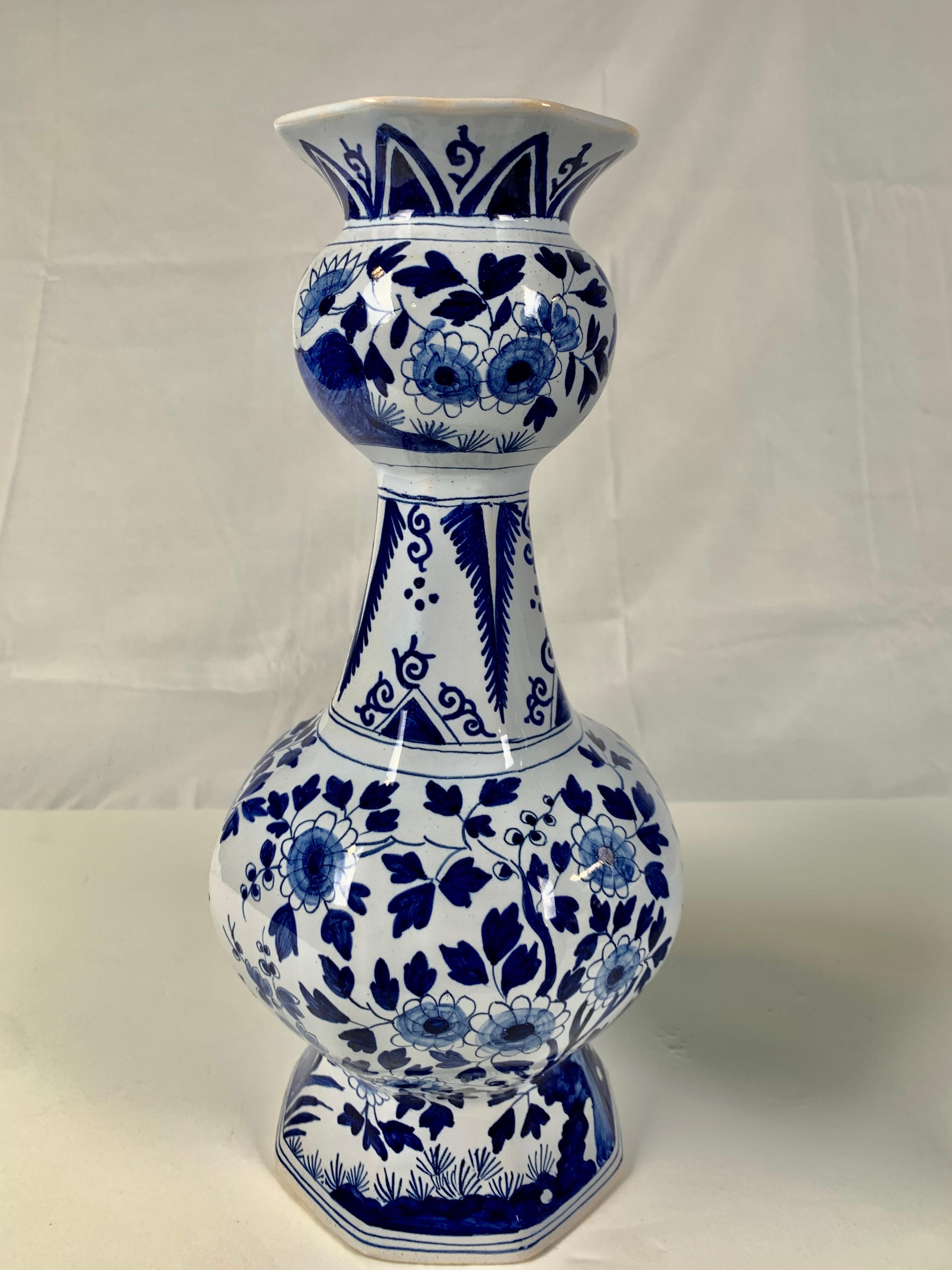 This pair of Delft-style vases were made in France circa 1900 by the esteemed firm of Edmé Samson et Cie.
 We see flowering trees and rockwork. The vases have a traditional soft-edged octagonal shape and beautiful Delft decoration. The two vases
