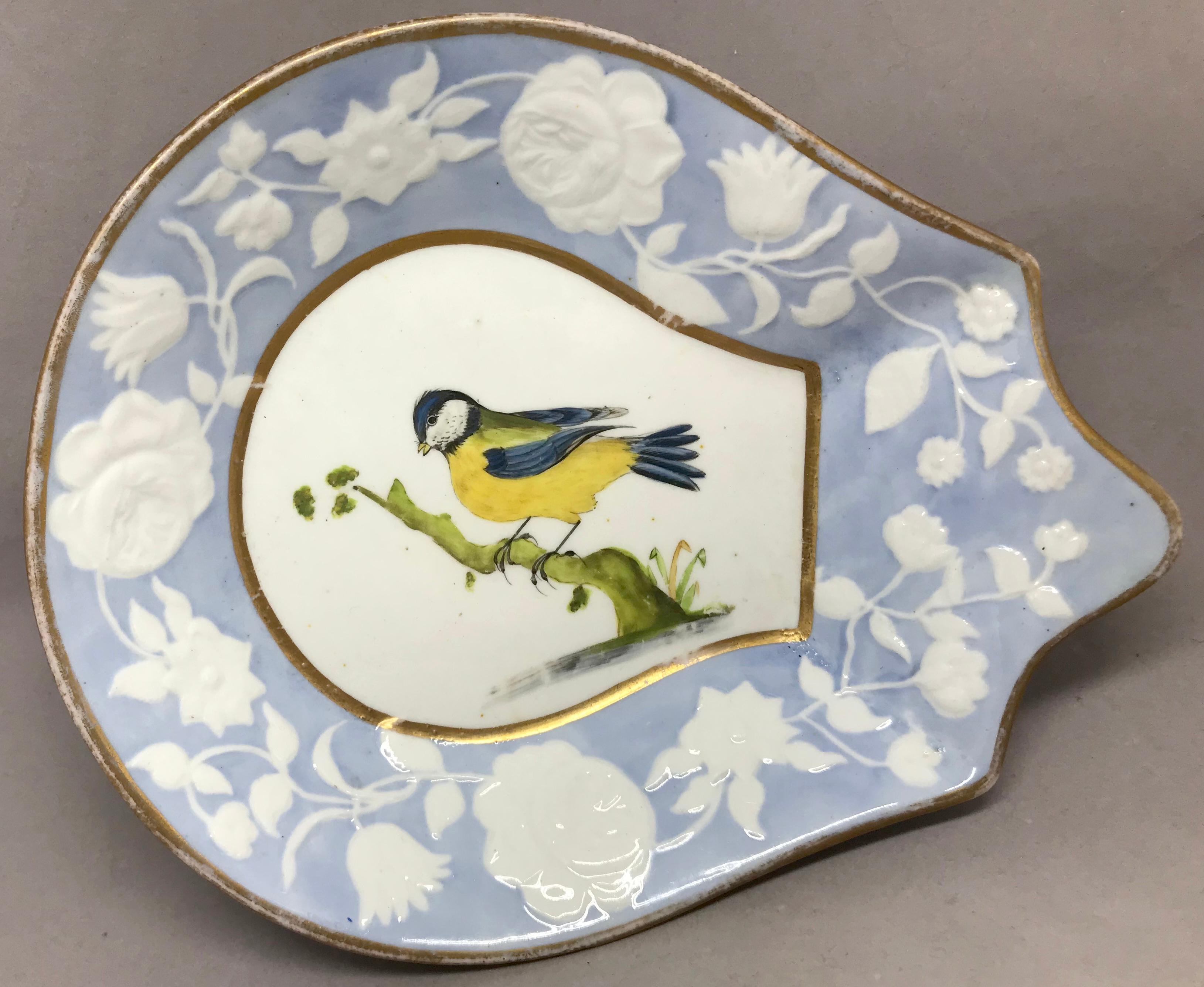Paire de plats à oiseaux en or bleu et blanc. Joli plat à sucrerie en forme de paire avec des entourages floraux bleu pâle, violet et blanc et des oiseaux peints à la main avec des bords dorés. Angleterre, vers 1840.
Dimensions : 8.5