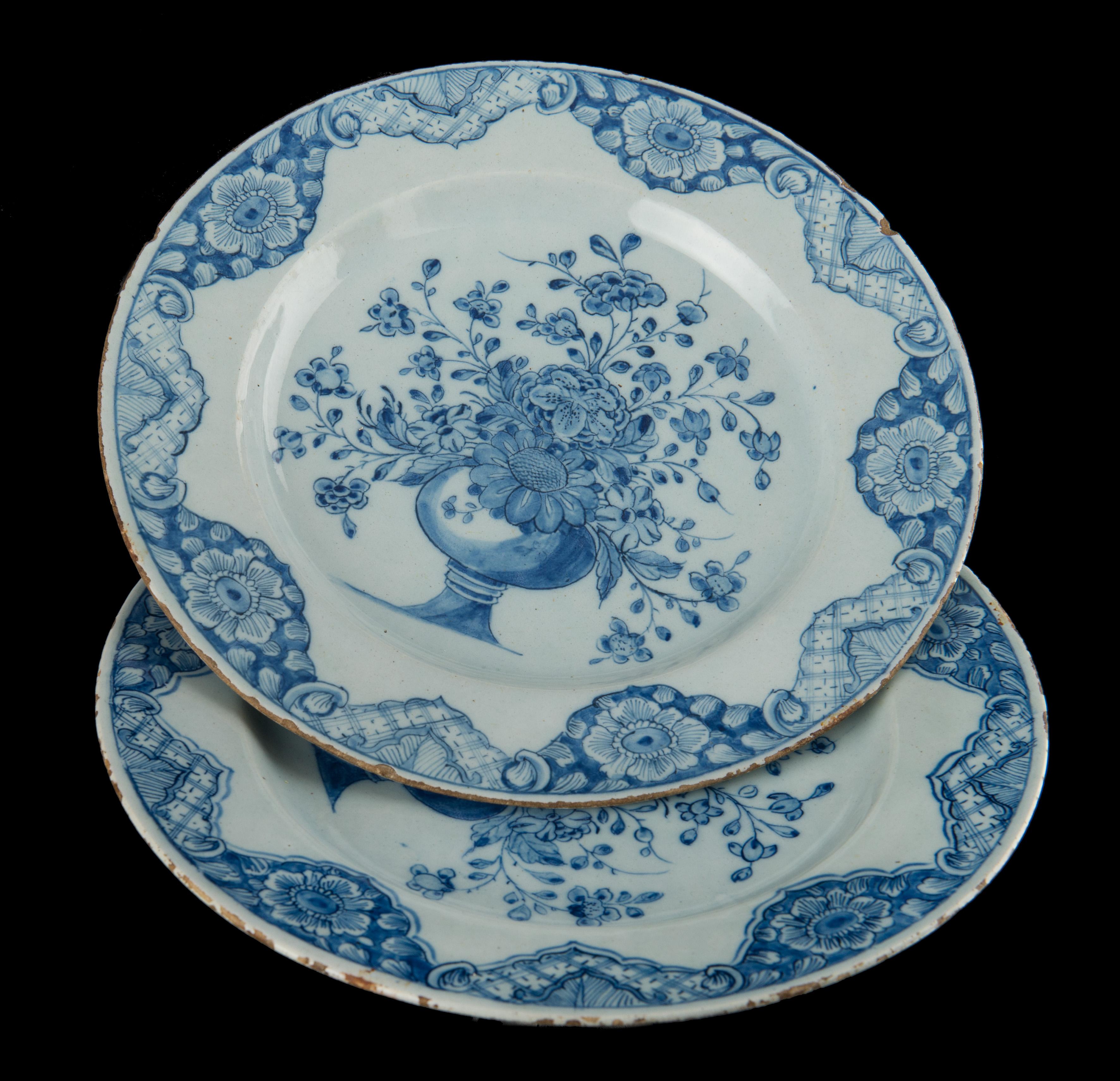 Pair of blue and white plates with flower vases. Delft, dated 1760. Mark: LV .

A pair of blue and white plates with a wide flange, painted in the center with an opulent bouquet of flowers in a vase on a high-waisted foot. The border is decorated