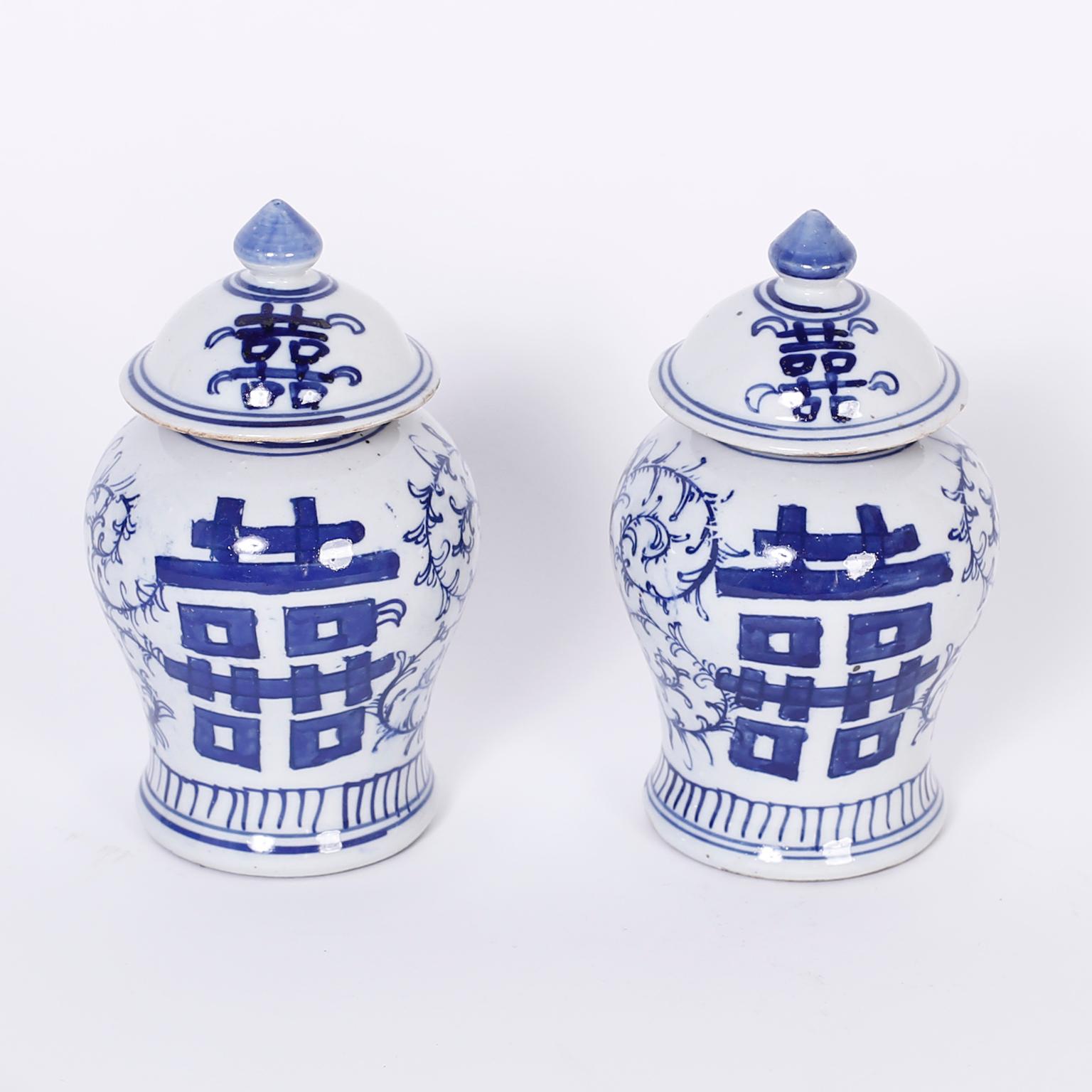 Chinesische blau-weiße Porzellan-Deckelgläser in klassischer Form und mit dem bekannten Symbol der Freude und Einheit des doppelten Glücks auf Vorder- und Rückseite verziert.
