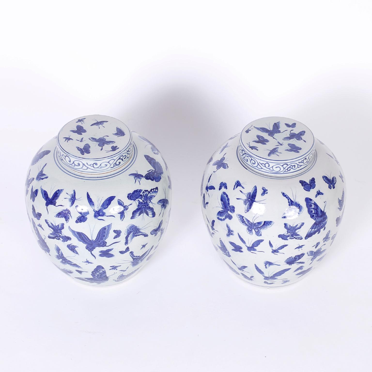 Pair of Chinese blue and white porcelain lidded ginger jars hand decorated with butterflies over a classic form.
 