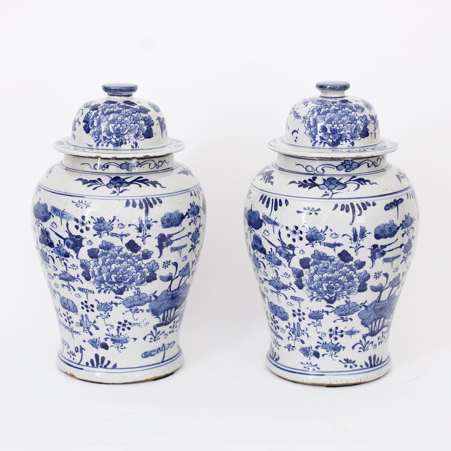 Pair of Chinese blue and white porcelain lidded ginger jars with Classic form hand decorated with waterlilies and asserted flowers all around.