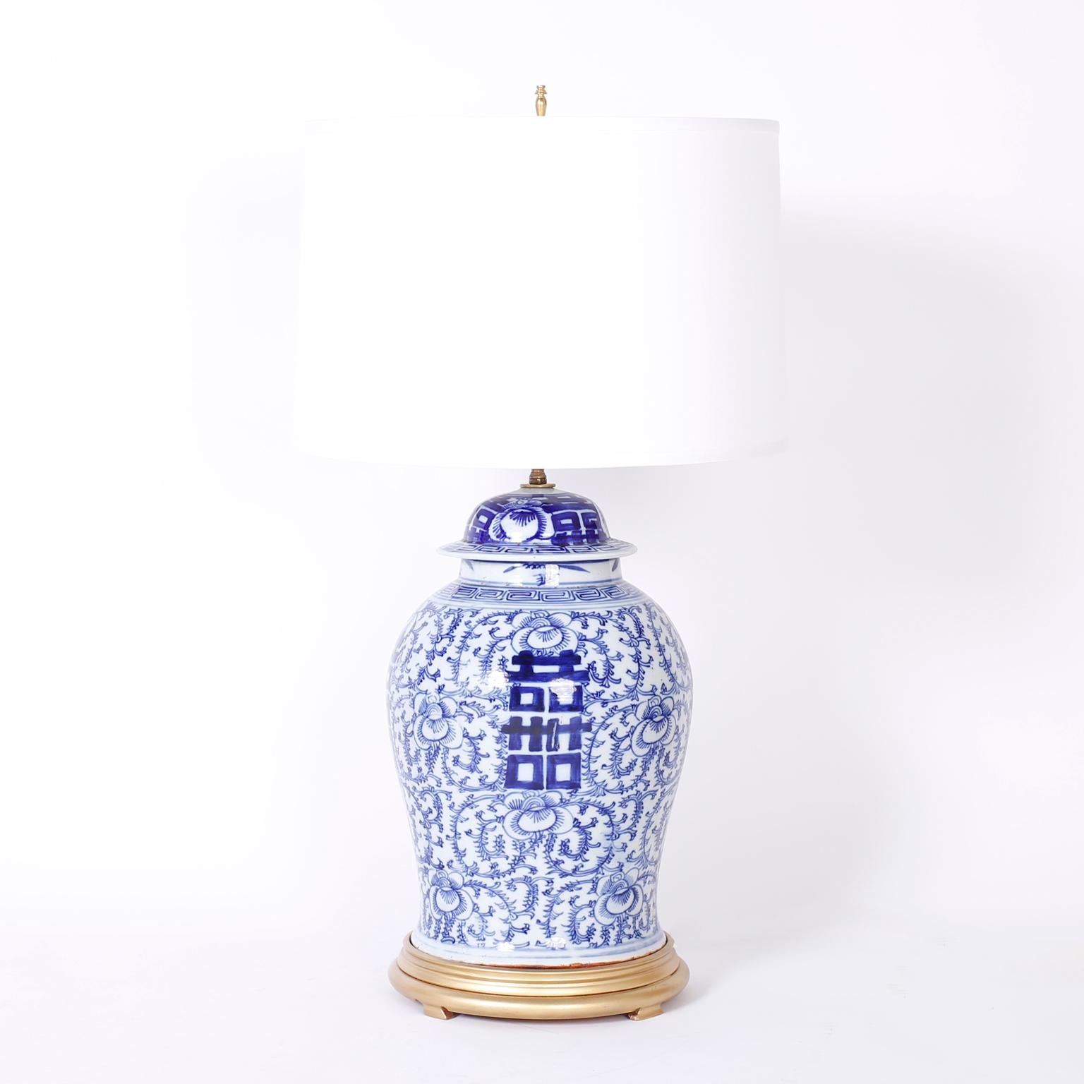 Pair of Chinese blue and white porcelain table lamps with happiness characters on an elaborate floral background, once antique ginger jars now table lamps.