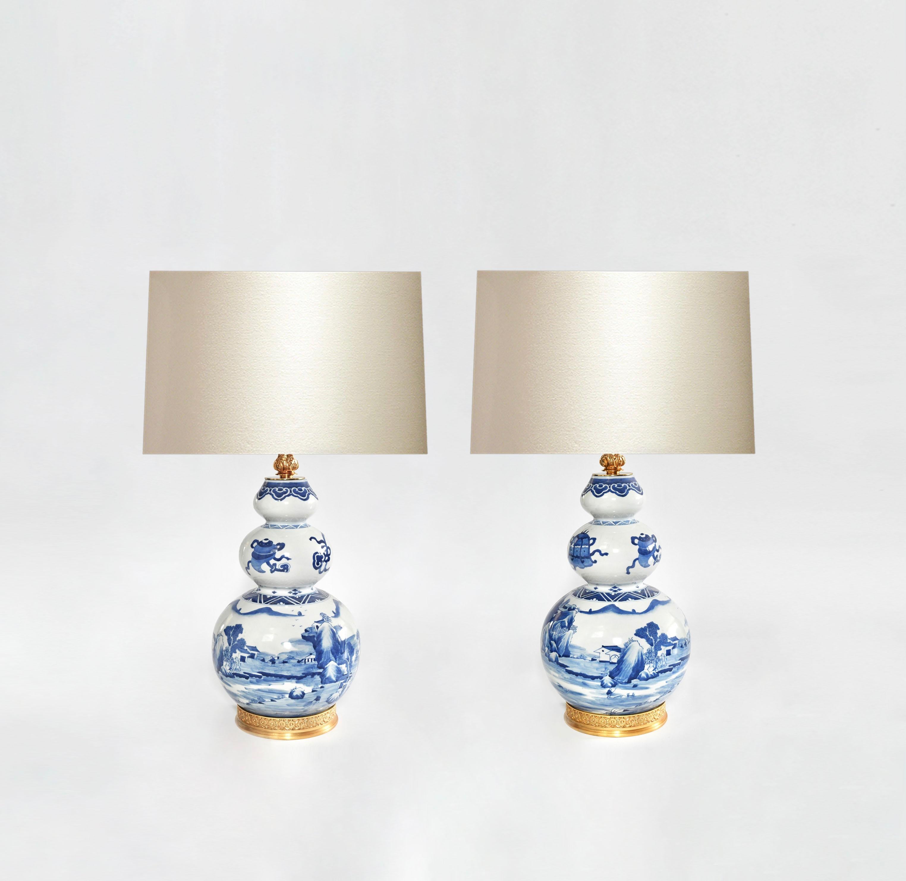 Pair of gourd style blue and white porcelain lamps with the fine paint of scenery in the mountain village. Fine cast gilt brass base. Created by Phoenix Gallery.
To the top of the porcelain: 18