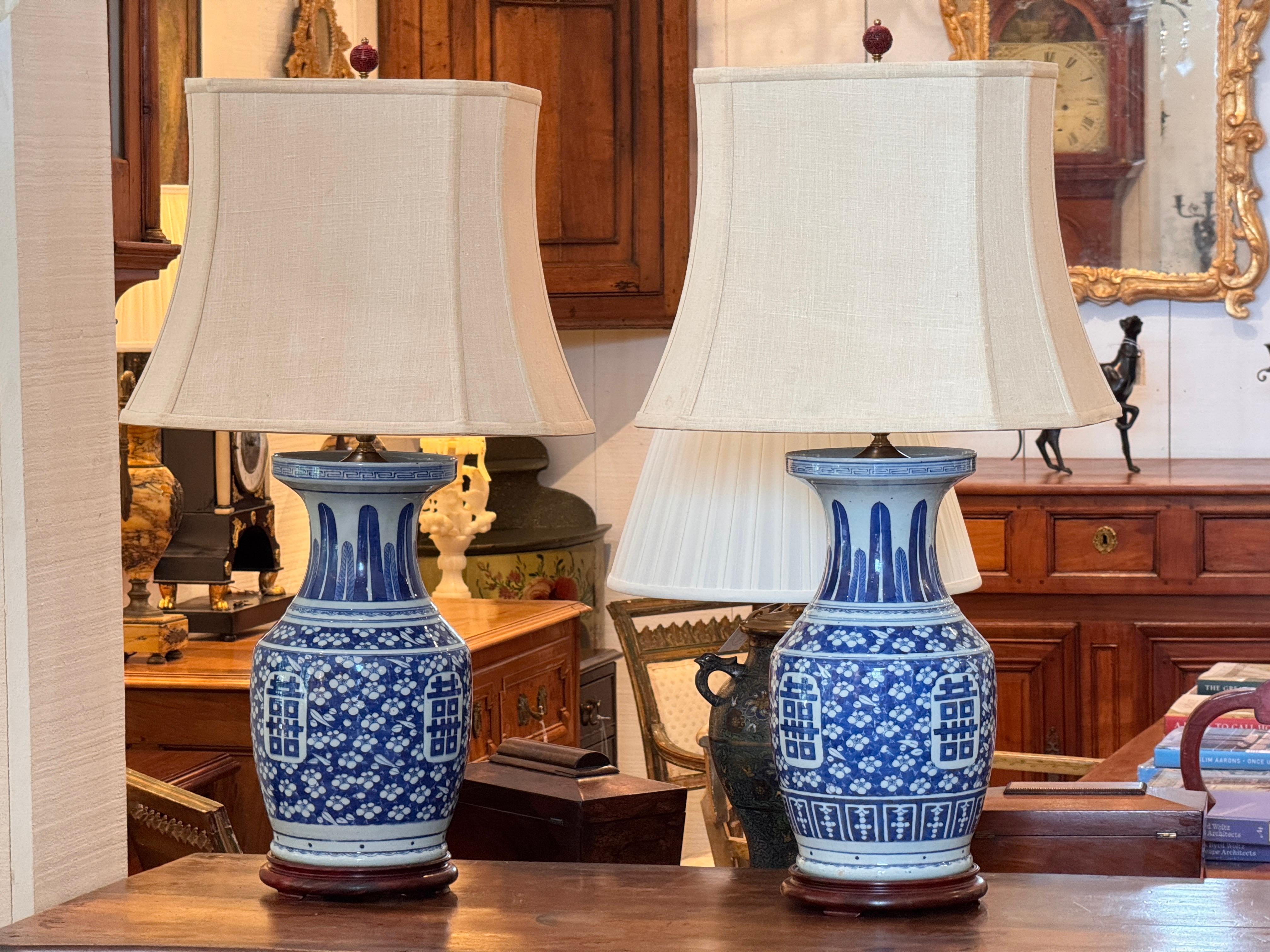 Une grande paire de vases en porcelaine bleue et blanche. Elles ont été converties en lampes.