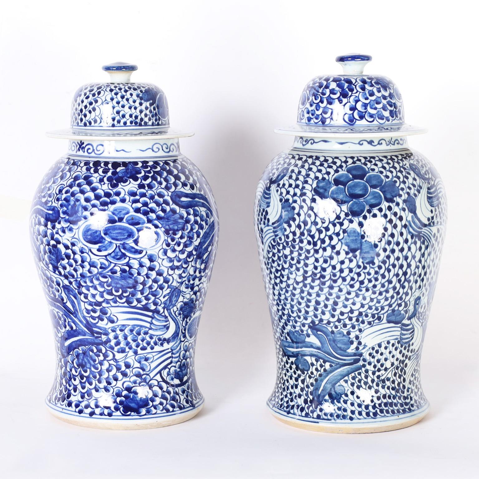 Pair of Chinese blue and white porcelain lidded jars with classic form hand decorated with bold designs of fauna and flora, in the Chinese Export manner.
