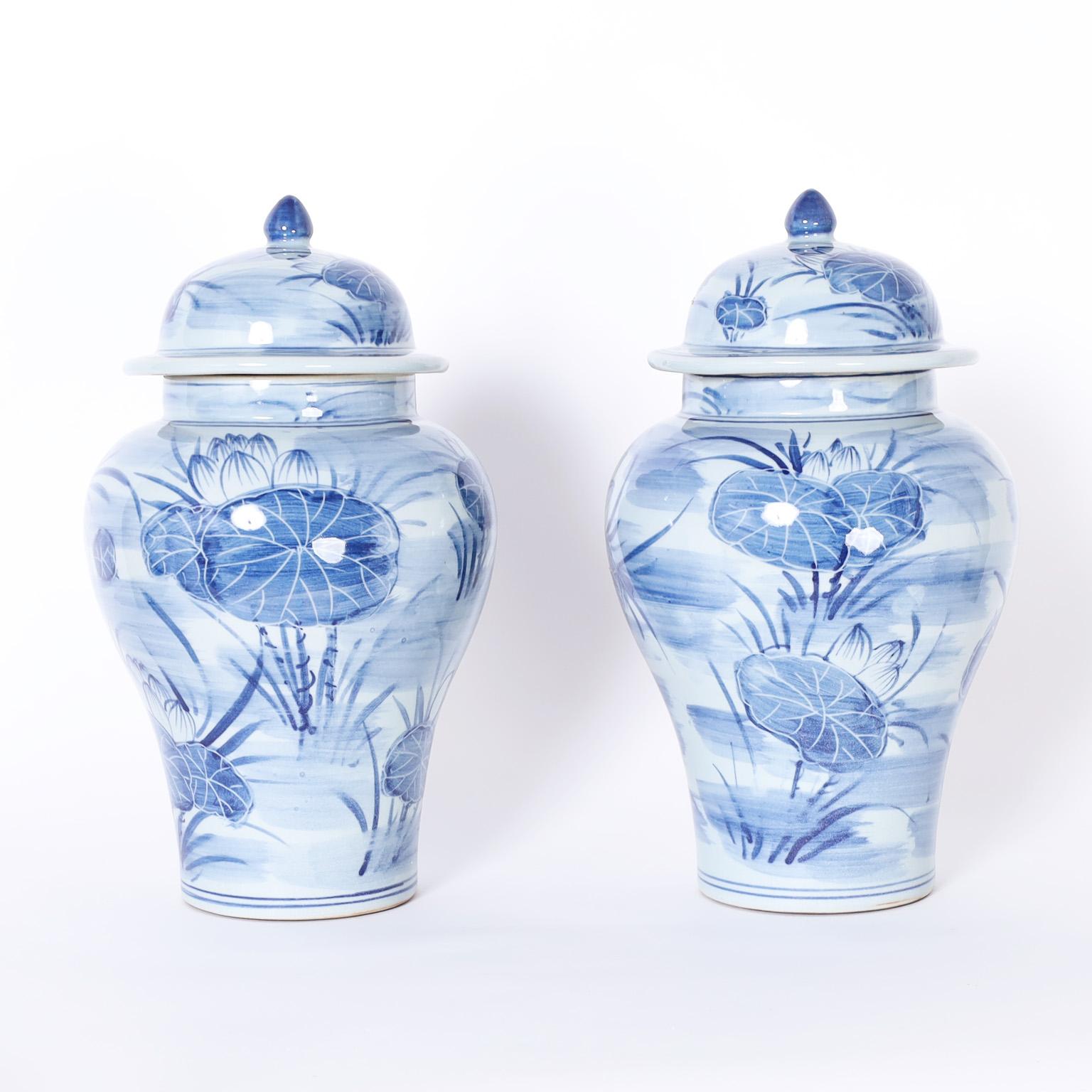 Pair of Chinese blue and white porcelain lidded ginger jars with classic form hand decorated with Water Lilies all around.