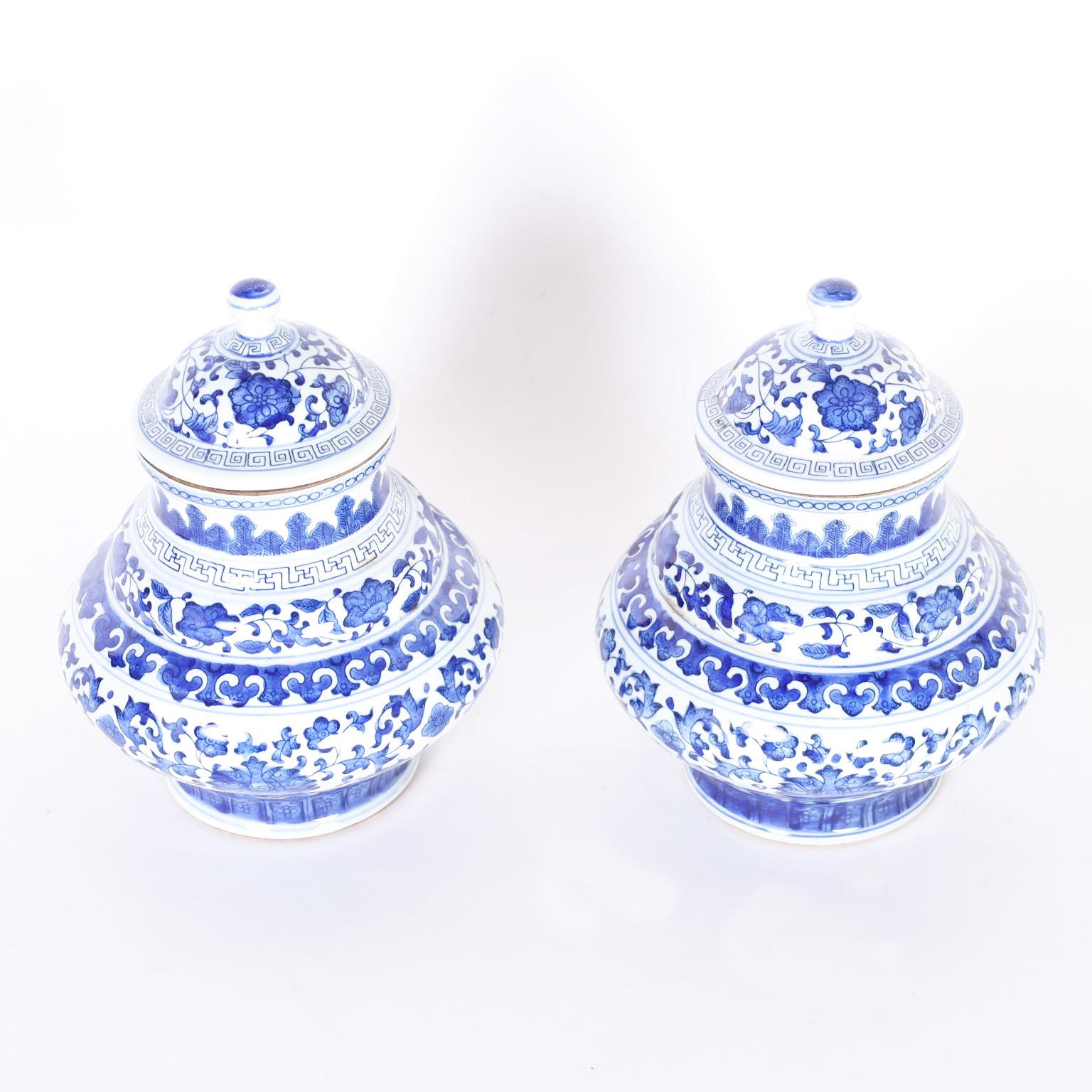 Pair of Chinese blue and white porcelain urns with a round fluid form and hand decorated with lovely floral designs.