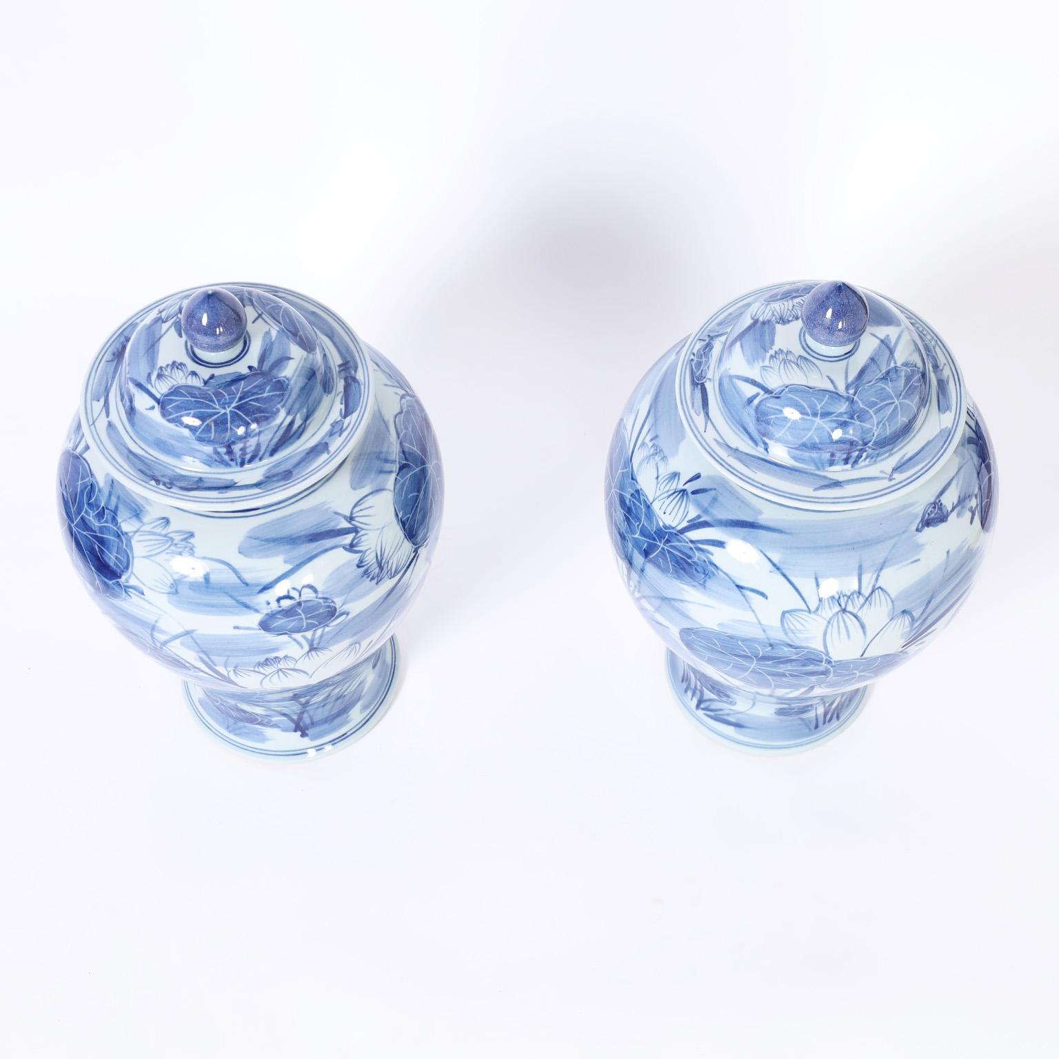 Exportation chinoise Paire d'urnes à couvercle en porcelaine bleue et blanche avec lys en vente
