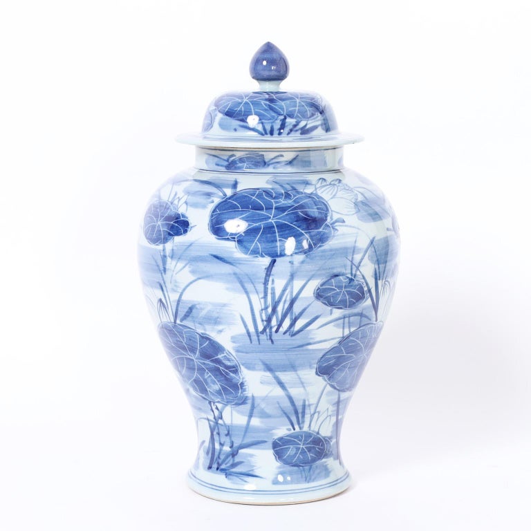 Pair of Blue and White Porcelain Lidded Urns with Lilies For Sale at