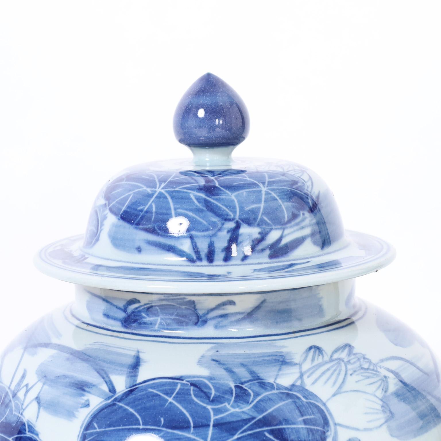 Paire d'urnes à couvercle en porcelaine bleue et blanche avec lys Bon état - En vente à Palm Beach, FL
