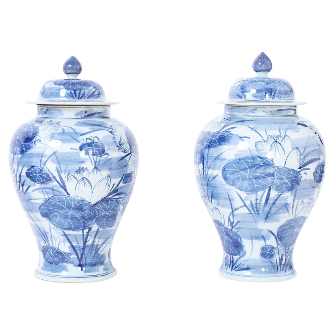 Pair of Blue and White Porcelain Lidded Urns with Lilies