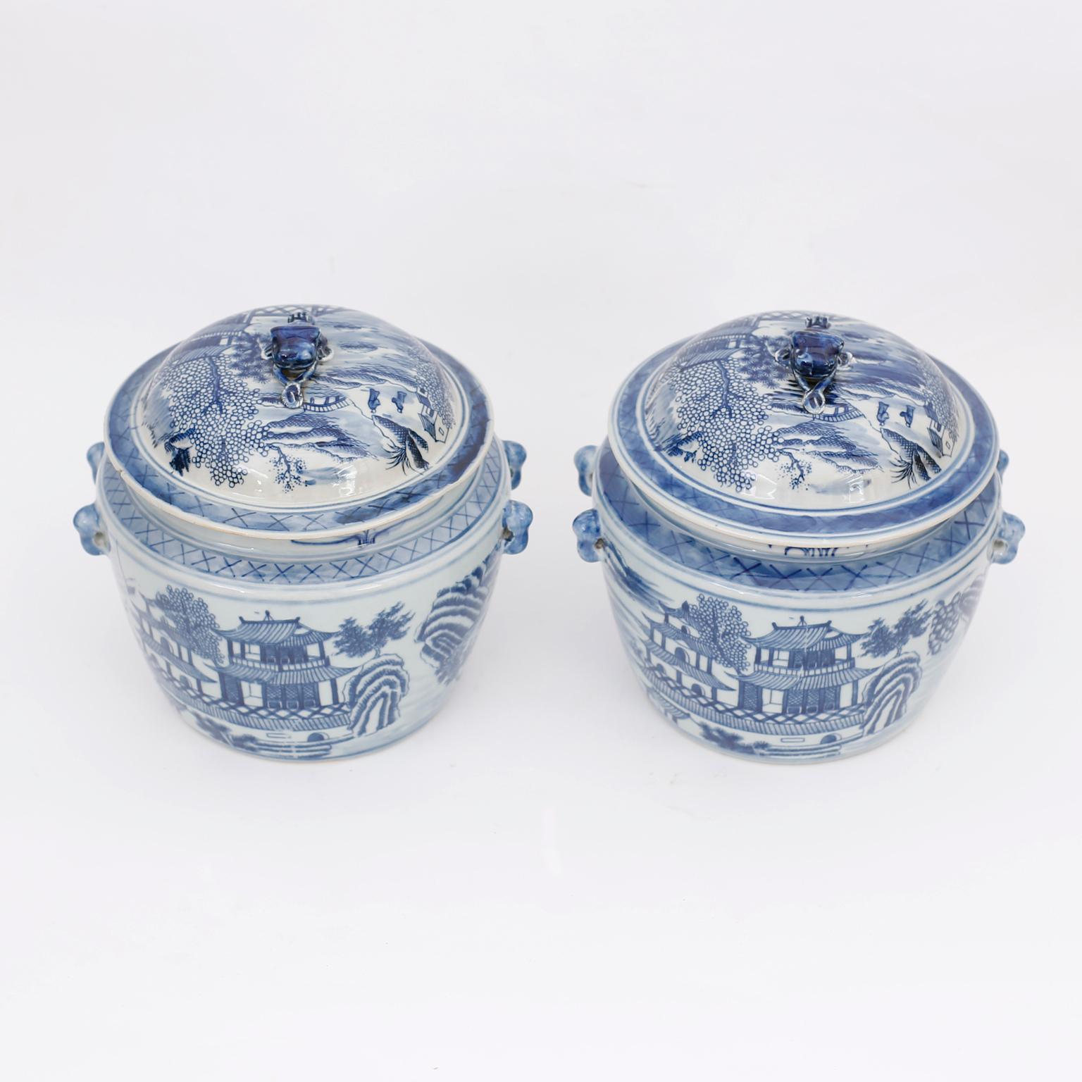 Pair of Chinese blue and white porcelain lidded pots with cat handles, hand decorated all around with pagoda motifs on the front and back.