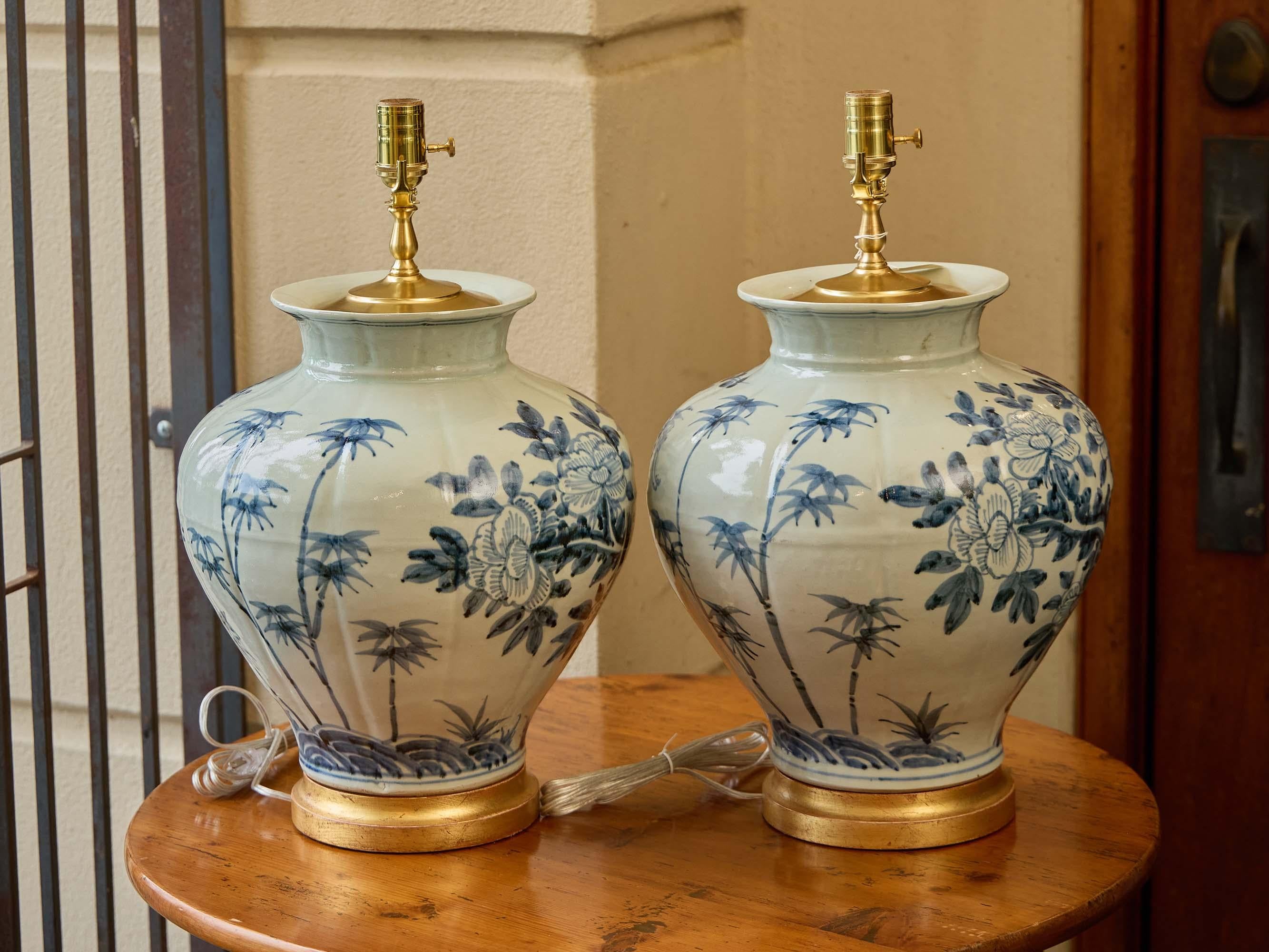 Questa raffinata coppia di lampade da tavolo nasce come vasi di porcellana, probabilmente realizzati nell'Asia orientale, e sono stati trasformati con cura per gli interni moderni. Le loro forme arrotondate sono dipinte a mano in luminose tonalità