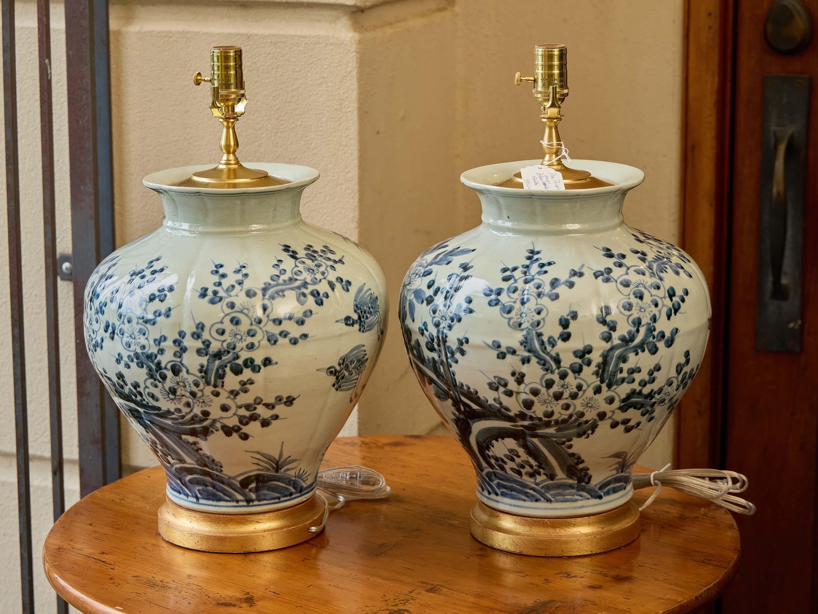 Dipinto a mano Coppia di lampade a vaso in porcellana bianca e blu con pennellate floreali e base dorata in vendita