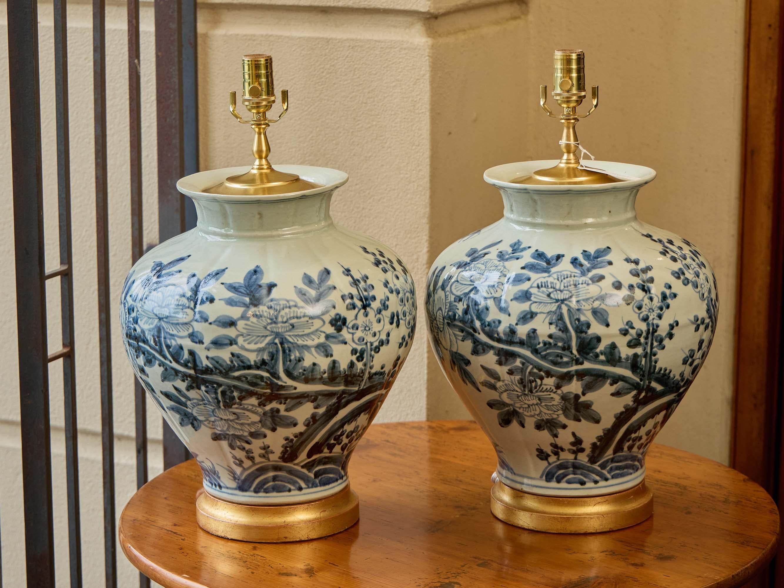 Porcellana Coppia di lampade a vaso in porcellana bianca e blu con pennellate floreali e base dorata in vendita