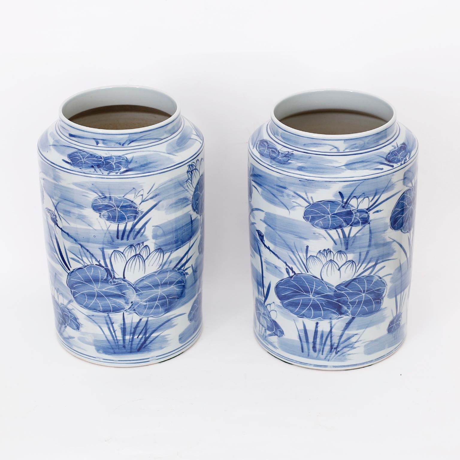Pair of Chinese blue and white vases with classic form and hand decorated in an unusual modern style with a waterlily motif all around.