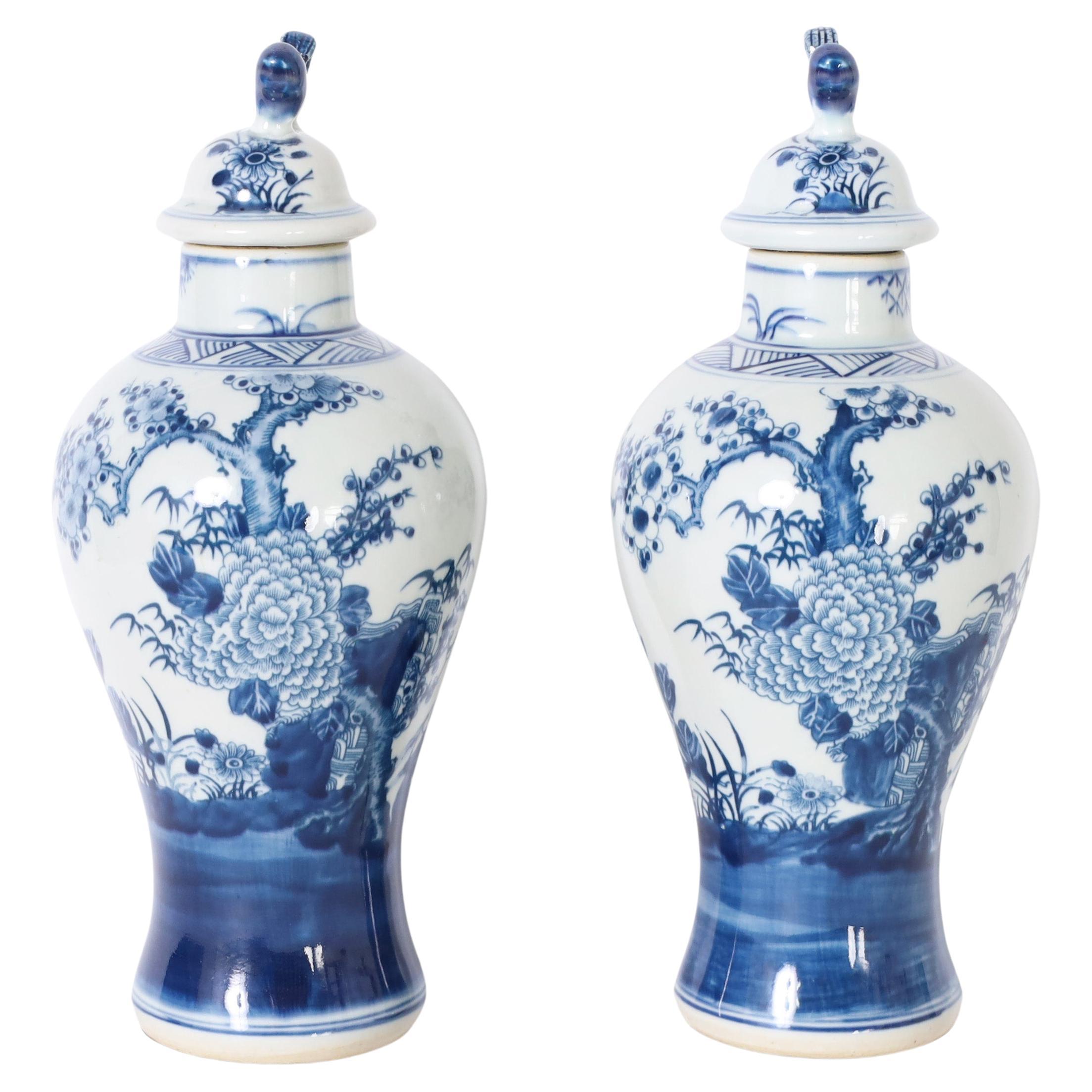 Pair of Blue and White Urns or Jars With Flowers For Sale