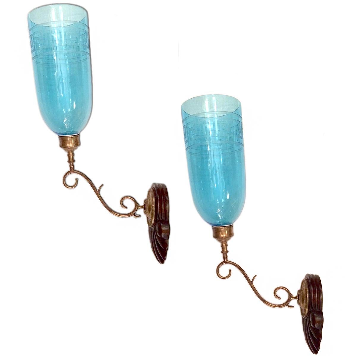 A pair of Anglo-Indian single arm sconces with light blue etched hurricanes, with Greek Key design. Wooden backplates have been refinished and wired.
Measurements:
24