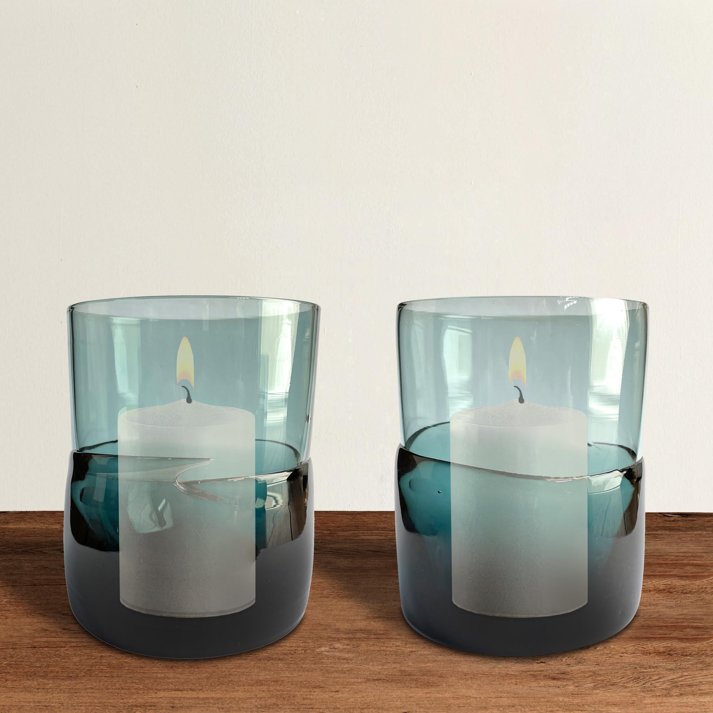 A fabulous pair of blown glass-votive candle hurricanes with heavy slump glass bases in a beautiful teal blue color. Perfect for candles, but also work well as small vases for your dining table or on a mantle.