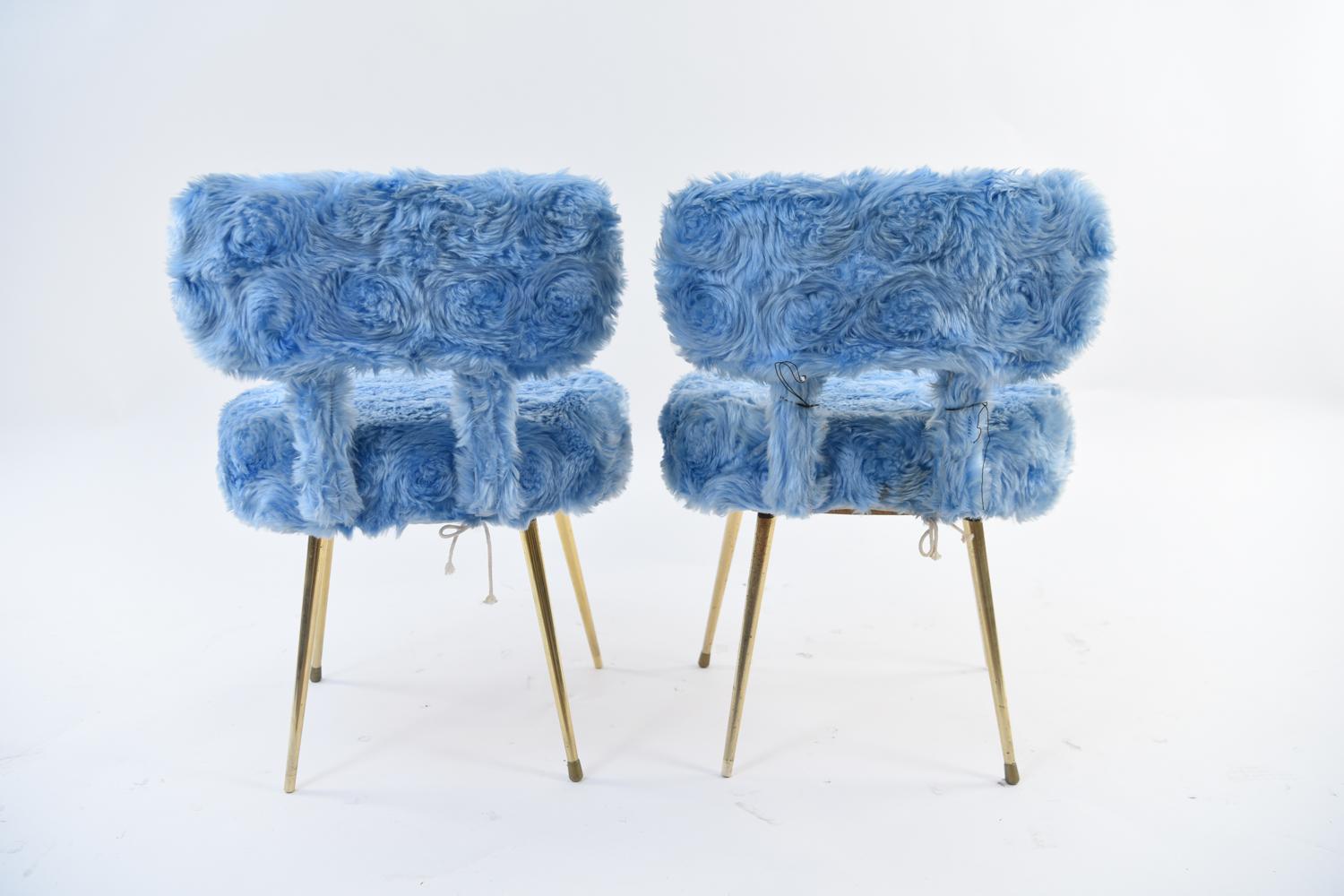 A stylish and comfortable pair of small side chairs featuring aquamarine blue faux-fur slipcovers. Slipcovers are easily removable for effortless cleaning and reupholstering! Chairs are constructed from bent plywood, sturdy particle board, and metal
