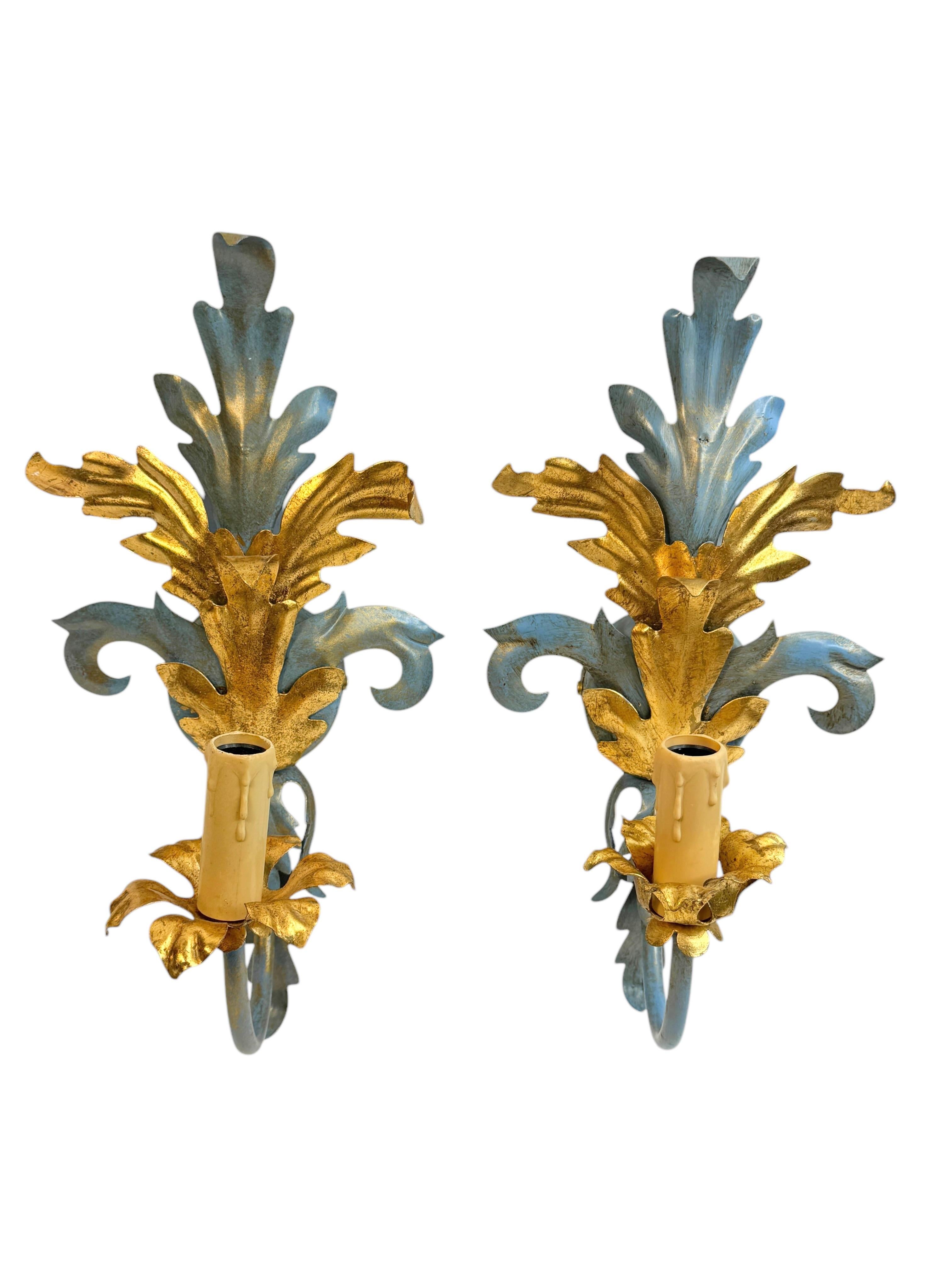 Verleihen Sie Ihrem Zuhause einen Hauch von Opulenz mit diesem charmanten Set von Wandleuchtern. Perfekter hellblauer Farbton und vergoldete farbige Blätter, die jedes schicke oder eklektische Heim aufwerten. Wir würden es gerne in einem