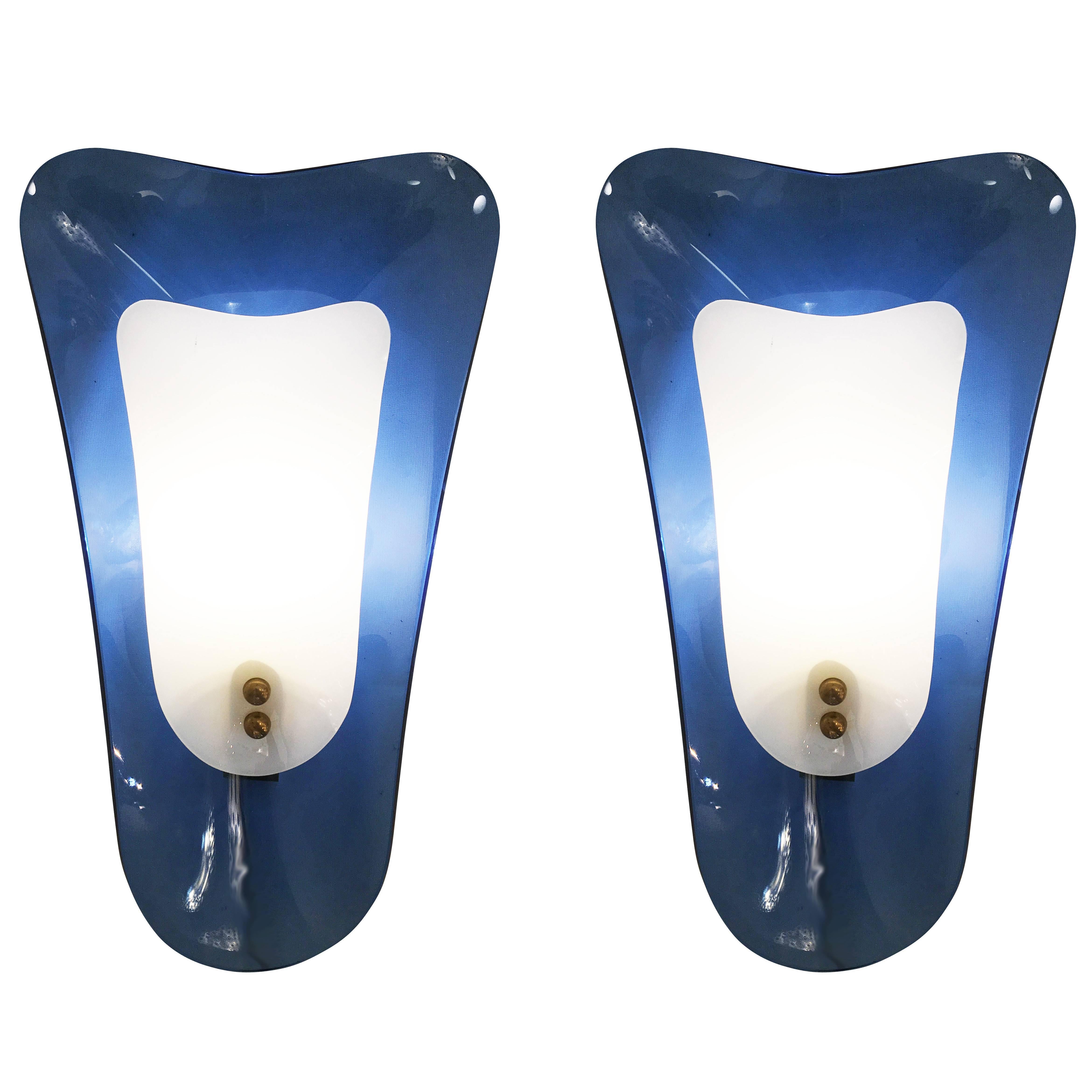 Pair of Mid-Century sconces by Cristal Arte composed of two contoured glass shades. The back shade is blue while the front one is white. Hardware holding one candelabra socket is is brass. Included but not shown, is newly manufactured brass back