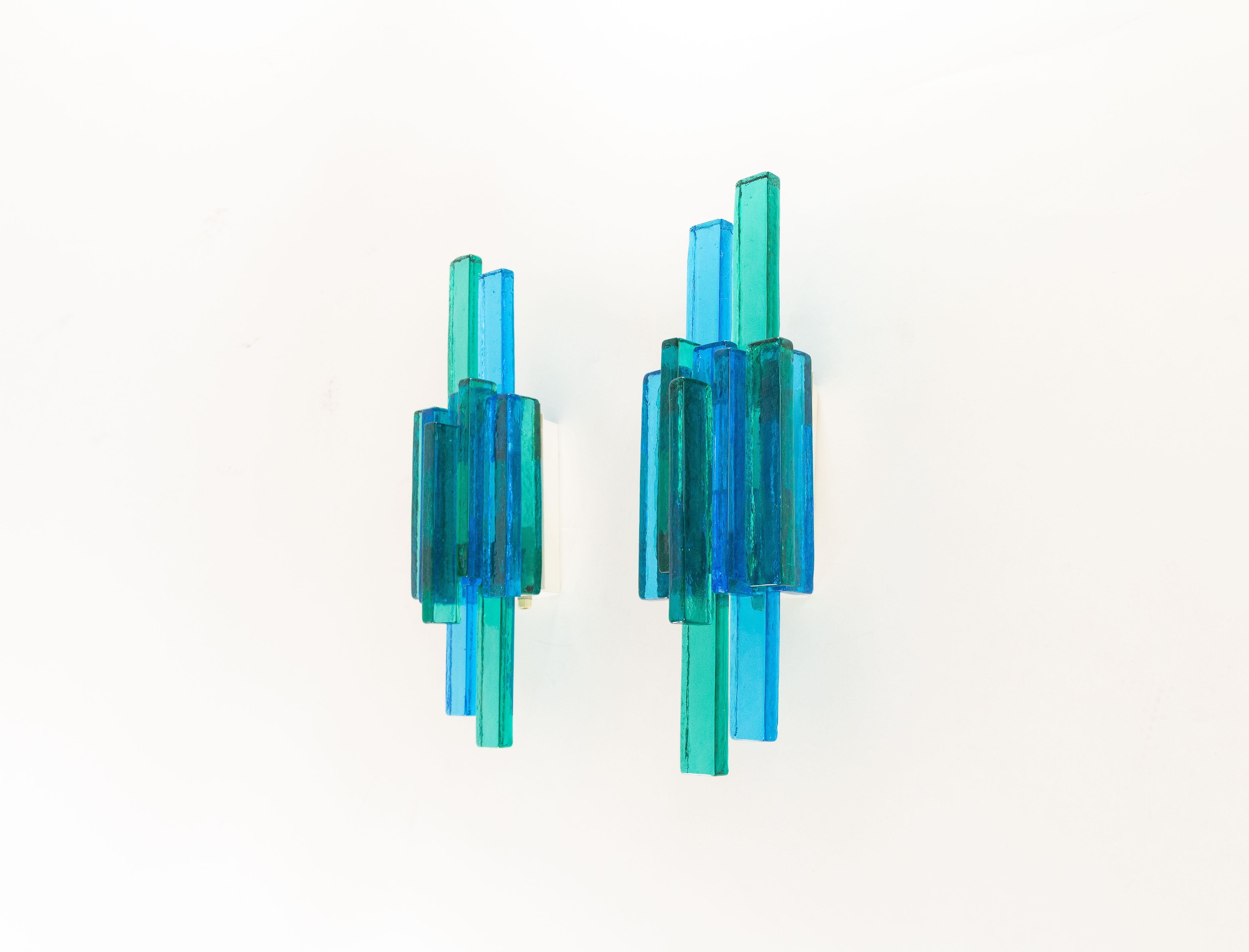 A pair of glass wall lamps designed by Svend Aage Holm Sørensen for his own company, Holm Sørensen & Co. 

Beautifully designed with marine and dark blue colored glass, granting the lamps a striking appearance.