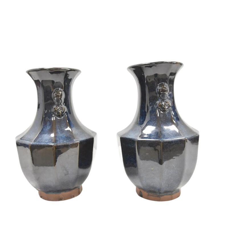 A pair of Chinese ceramic vases glazed in a shimmering blue with details at the neck on each side