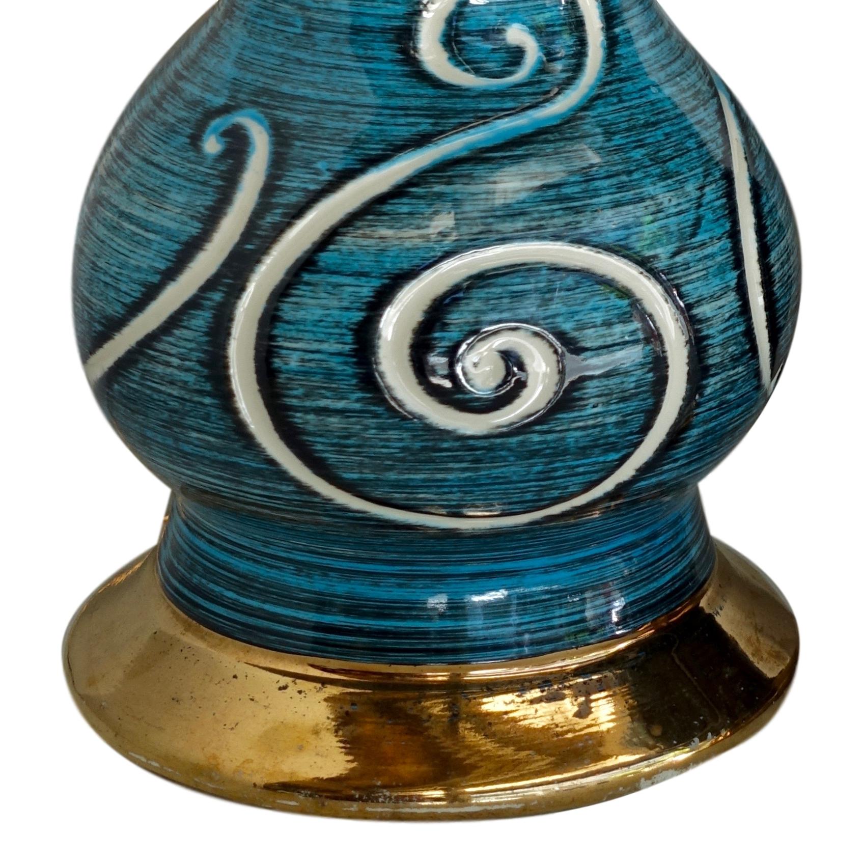 Une paire de lampes de table en porcelaine française datant des années 1950, avec un motif de volutes sur des bases en glaçure bleue et dorée.

Mesures :
Hauteur du corps : 16
Diamètre (au plus large) : 6,75