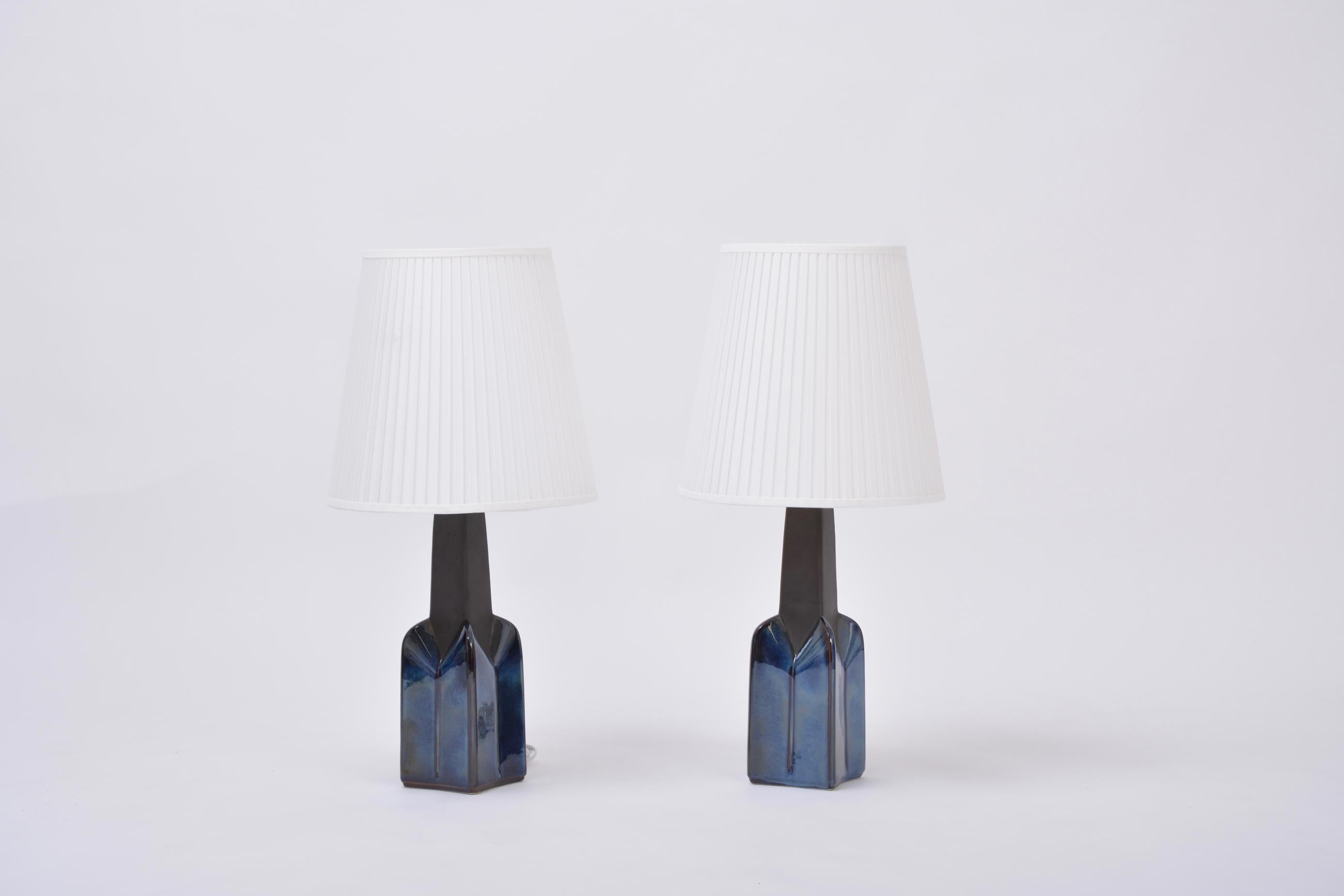 Pair of blue Mid-Century Modern stoneware lamps Model 1029 by Einar Johansen for Soholm.

Pair of tall table lamps made of stoneware with ceramic glazing in dark blue. Beautiful graphic shape of the base of the lamp. Designed by Einar Johansen and