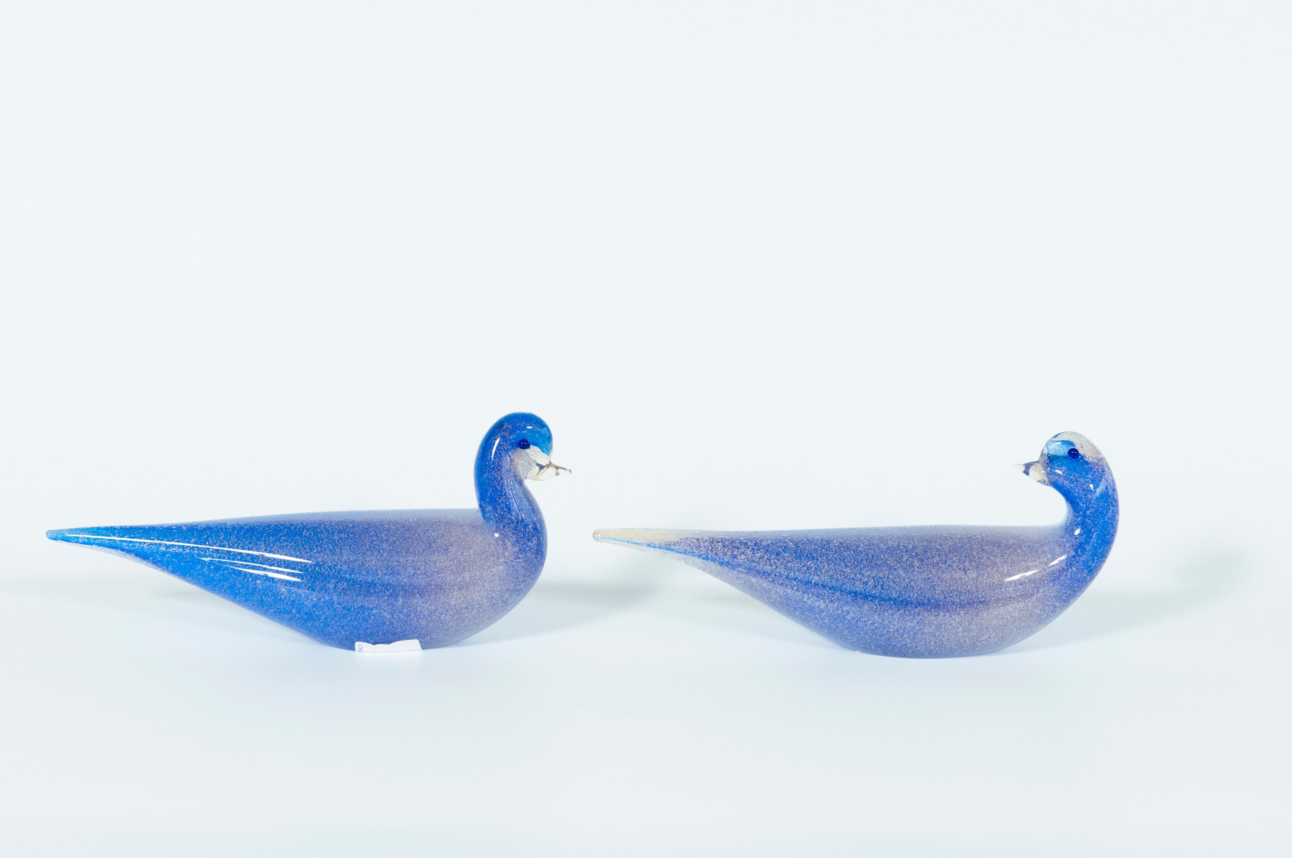 Paar blaue Murano-Glas-Entenskulpturen signiert Cenedese 1980er Jahre Italien mit versenkten Goldausführungen
Dieses kunstvolle Entenskulpturenpaar bringt einen Hauch venezianischer Schönheit und Tradition mit sich. Diese Kunstwerke zeichnen sich