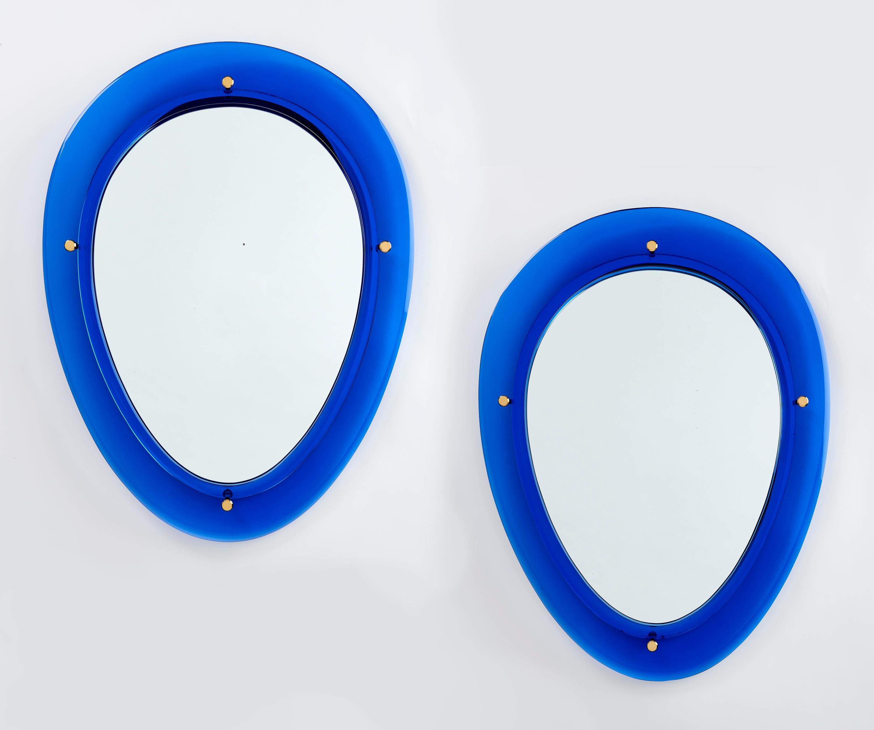 ITALY, 1960s
Pair of oval shaped blue glass mirrors, with nicely beveled glass frames and four polished brass mounts.
Sold and priced individually
Dimensions: 33 H x 25 W x 2 D.


