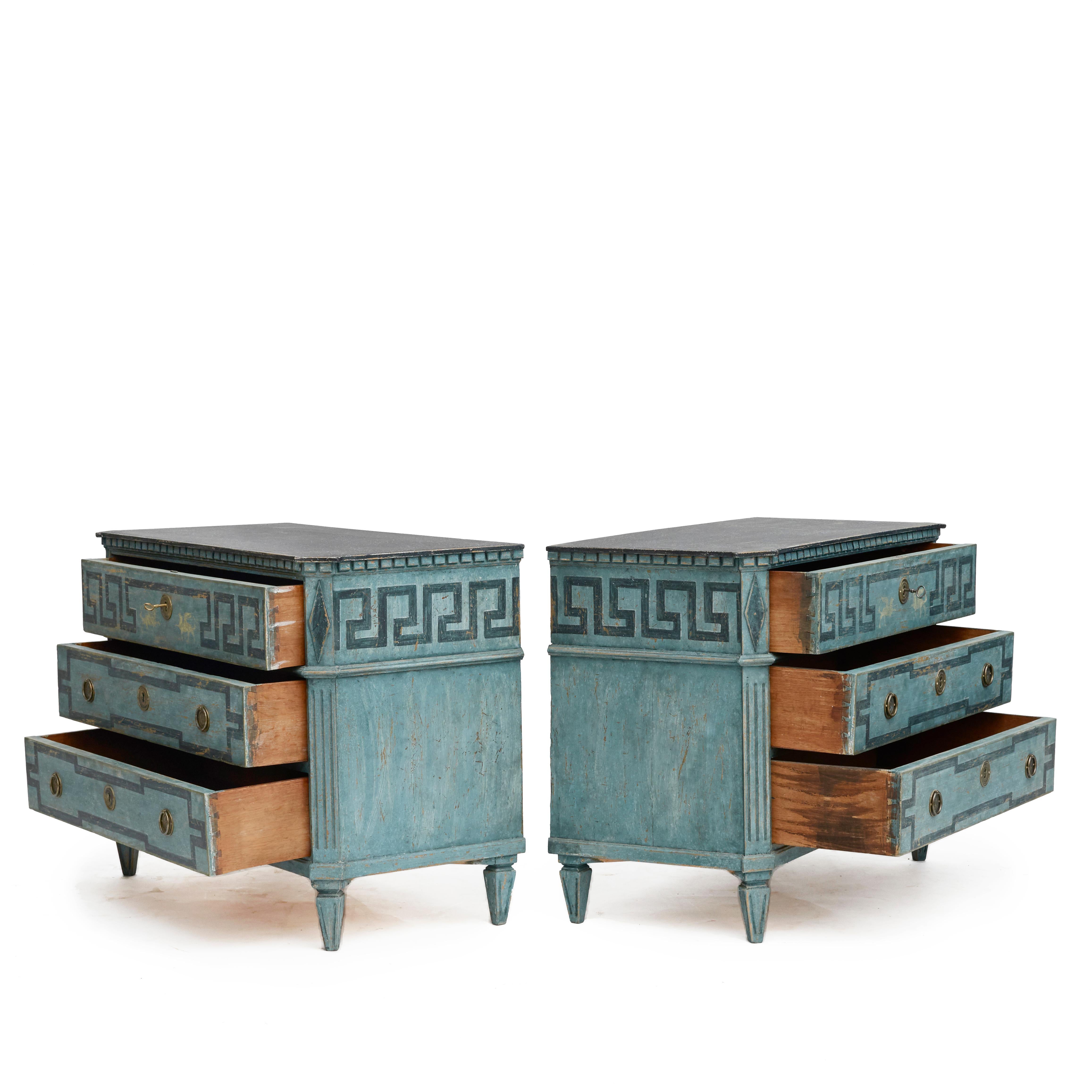 Pair of Swedish blue painted Gustavian style chest of drawers.

Each commode features a faux porphyry painted top and dentil moulded edge above three drawer. Upper drawer decorated with 