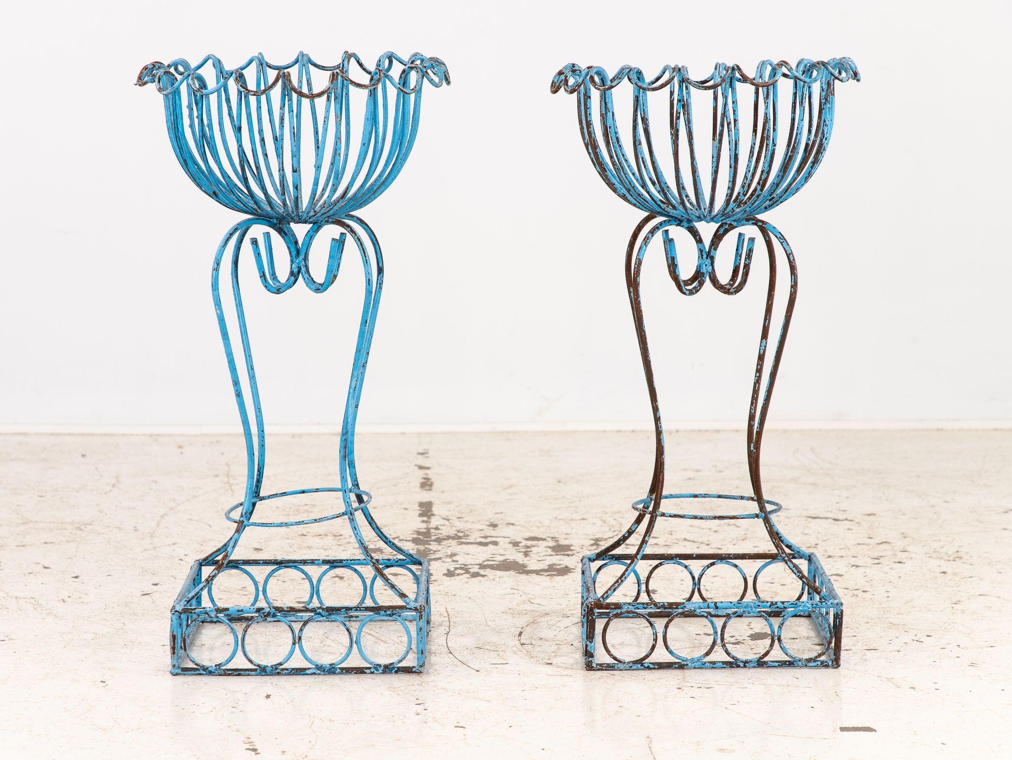 Un llamativo par de maceteros franceses vintage con pedestal, fabricados hacia 1960 y acabados en pintura azul huevo de petirrojo con una pátina desgastada por el tiempo. Cada maceta presenta una escultural tapa de cesta con detalles festoneados,