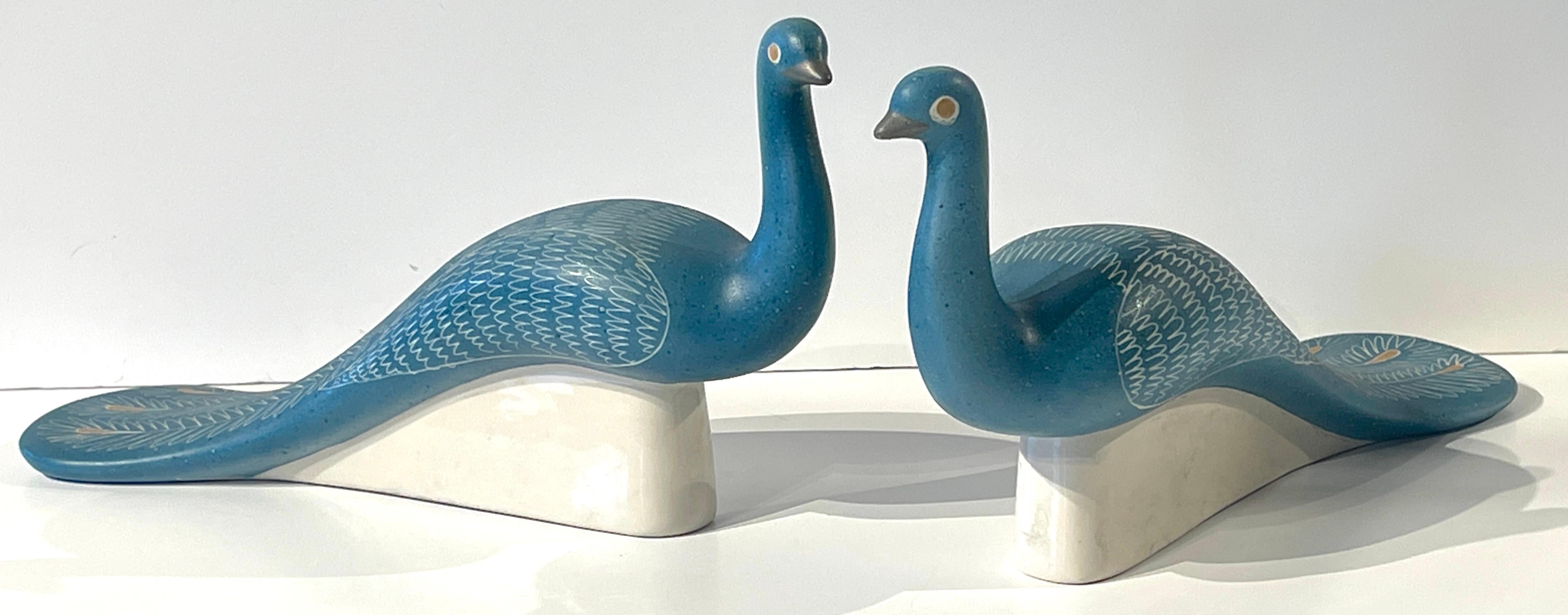 Paire de paons bleus sculptés, par Waylande Gregory
États-Unis, Circa 1950s
Chaque figure de grande taille, perchée sur un socle, est magnifiquement modelée et décorée, en émail bleu, avec des rehauts de dorure, plumes exécutées en sgrafitto, 
Les