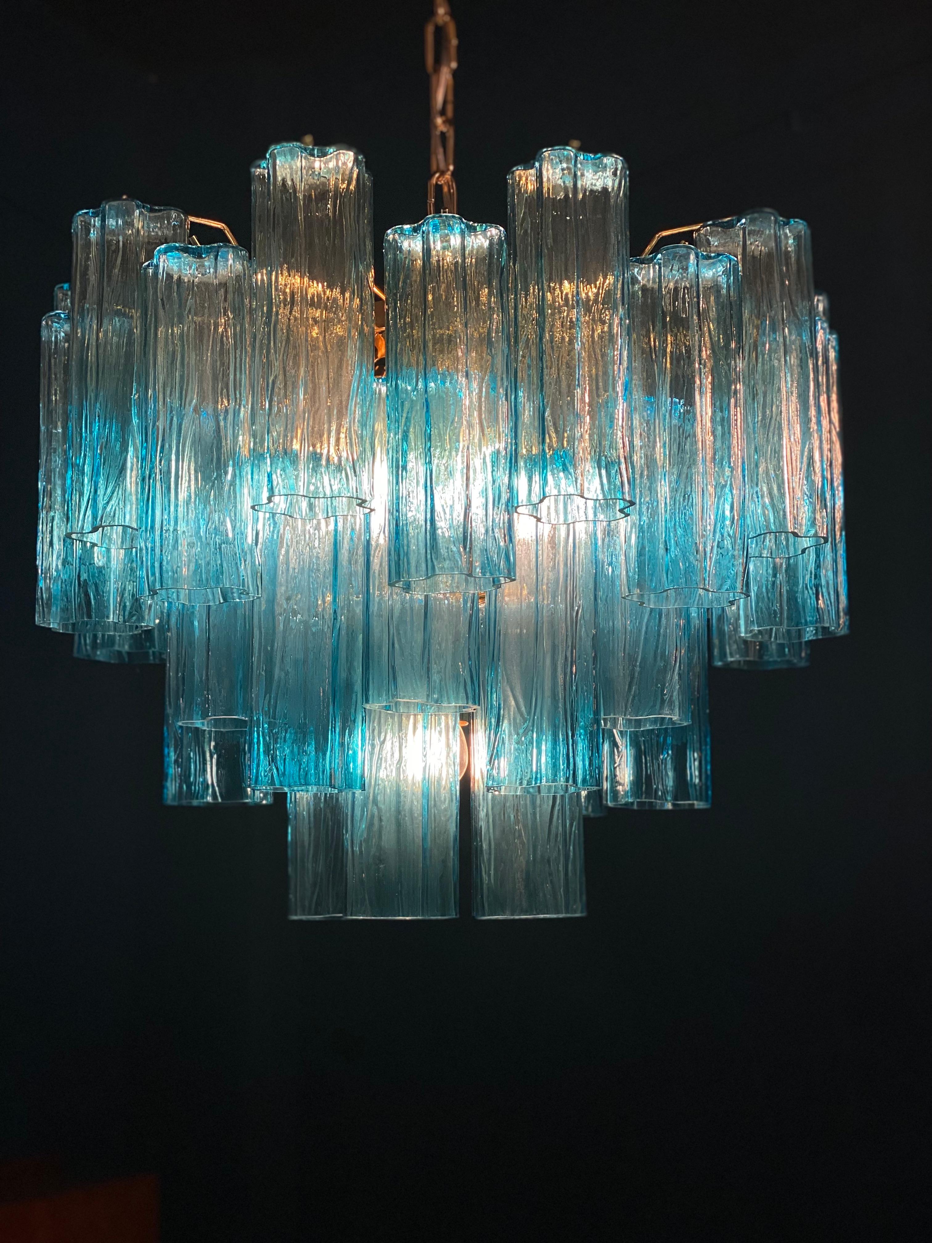 Amazing chandelier includes precious blu tronchi Murano glasses 20 cm long.
Gold-plated metal structure on three levels.
We can customize the frame and glass color on request.
 Seven E27 light bulbs wired for US standards.
 Height without chain cm