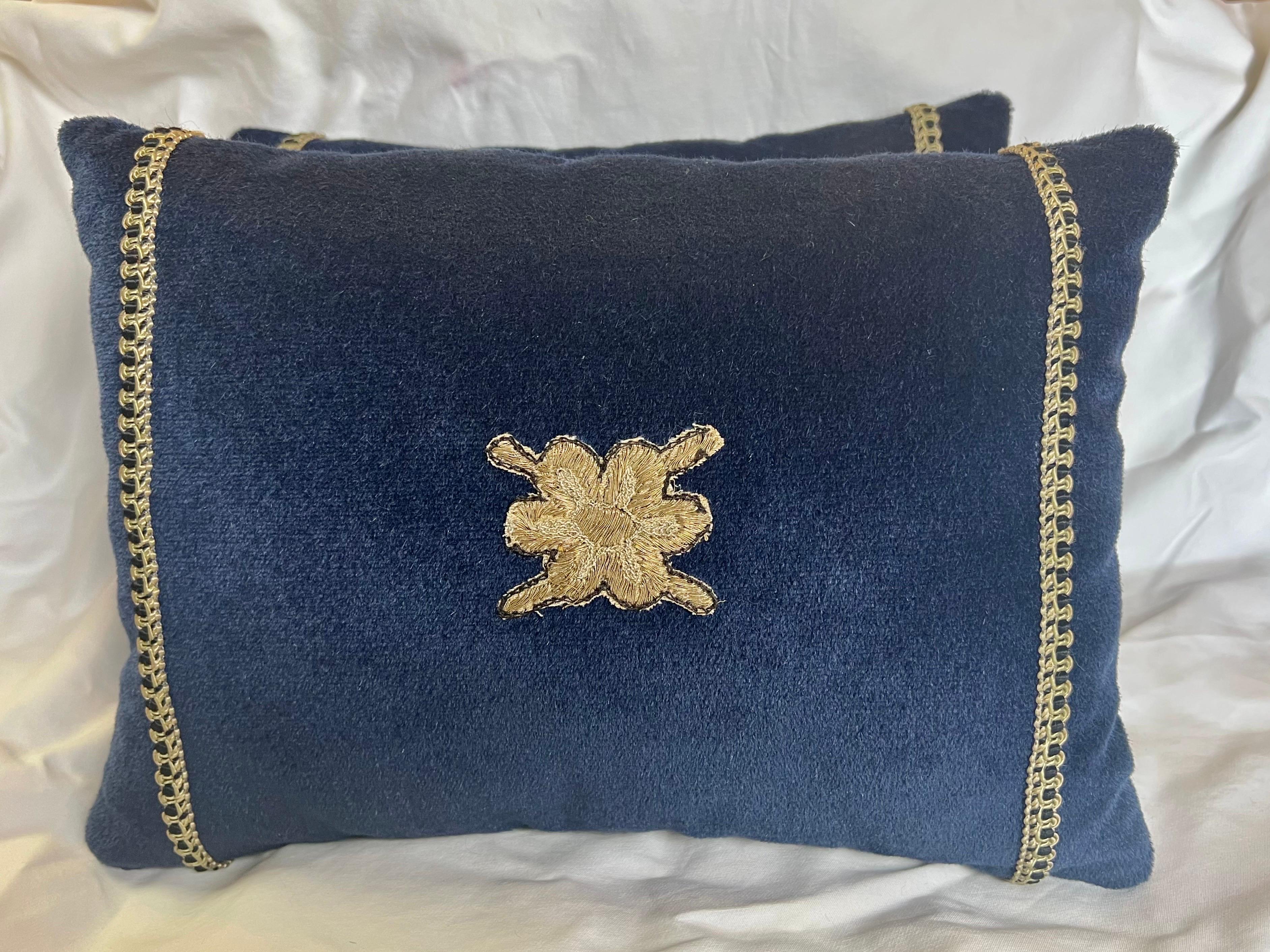 Pair of custom blue mohair pillows with 19th century appliques in the center and a small gimp on either side of applique. Down inserts, zipper closures.