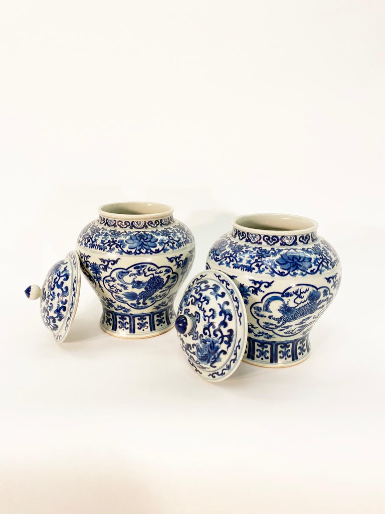 Antique Chinese blue and white ginger jars with lids. Painted with dragons in clouds amongst repeating floral patterns. Jaiqing dynasty marks on bottoms of both jars but believed to be of a later period. 

20th century Chinese 

Measures: Height