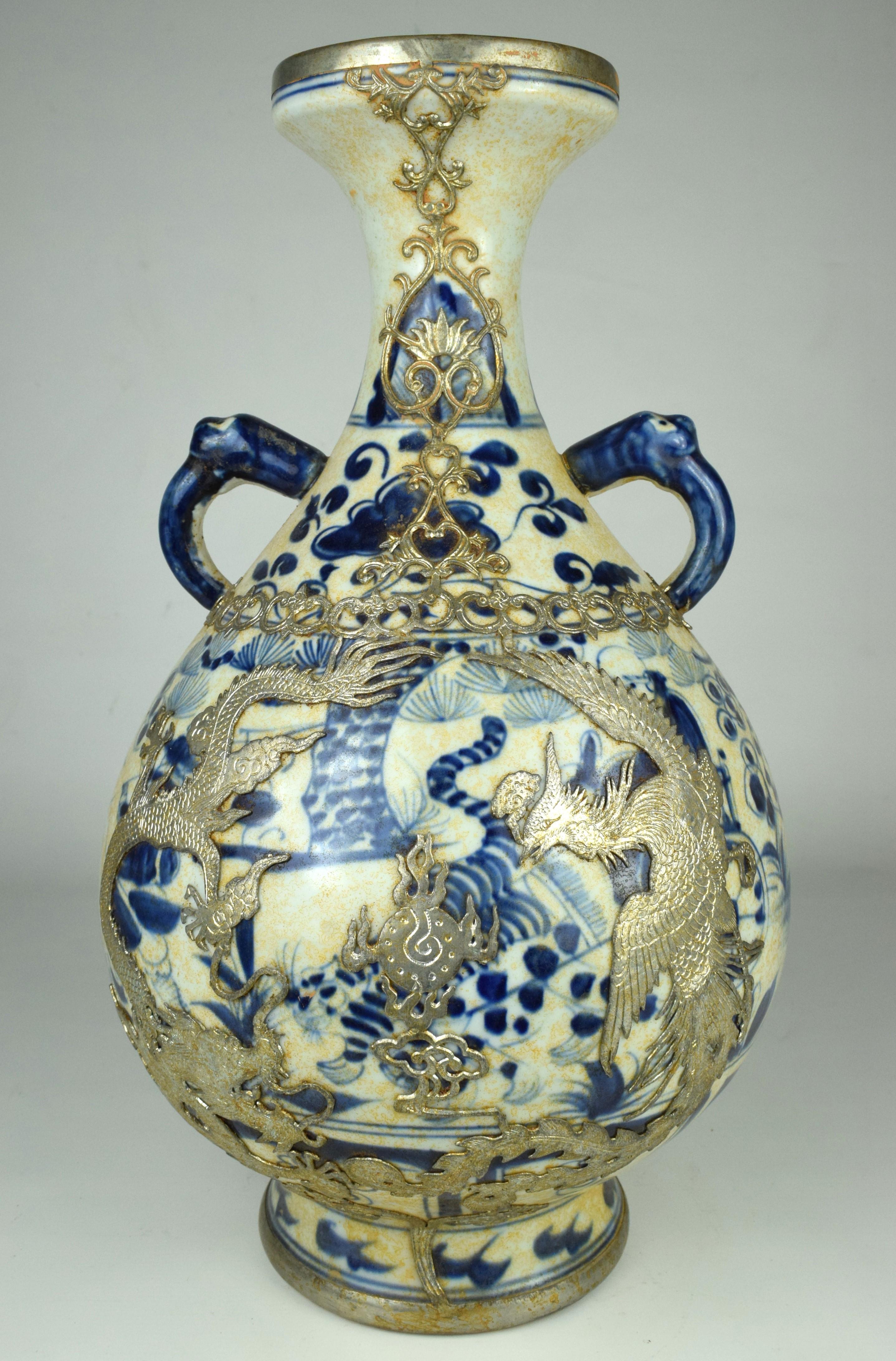 The pair of Blue White Porcelain Vases with Gilt Silver Phoenix Dragons, dating from the 20th century, is an exquisite examples of decorative art, blending traditional Chinese porcelain craftsmanship with intricate silver detailing.

The vases have