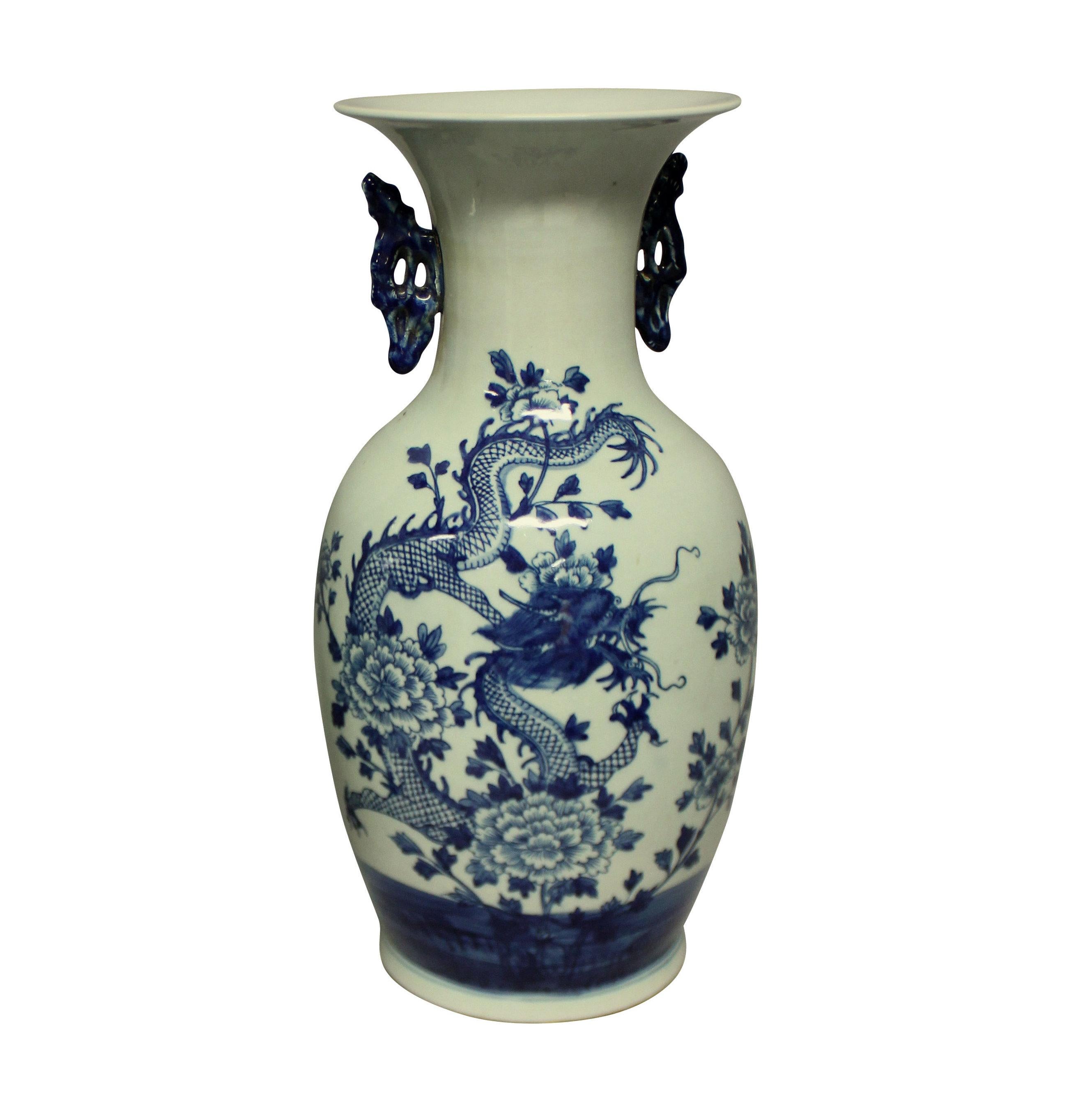 A pair of Chinese blue and white twin handled vases depicting dragons. The background color is a pale duck egg.
