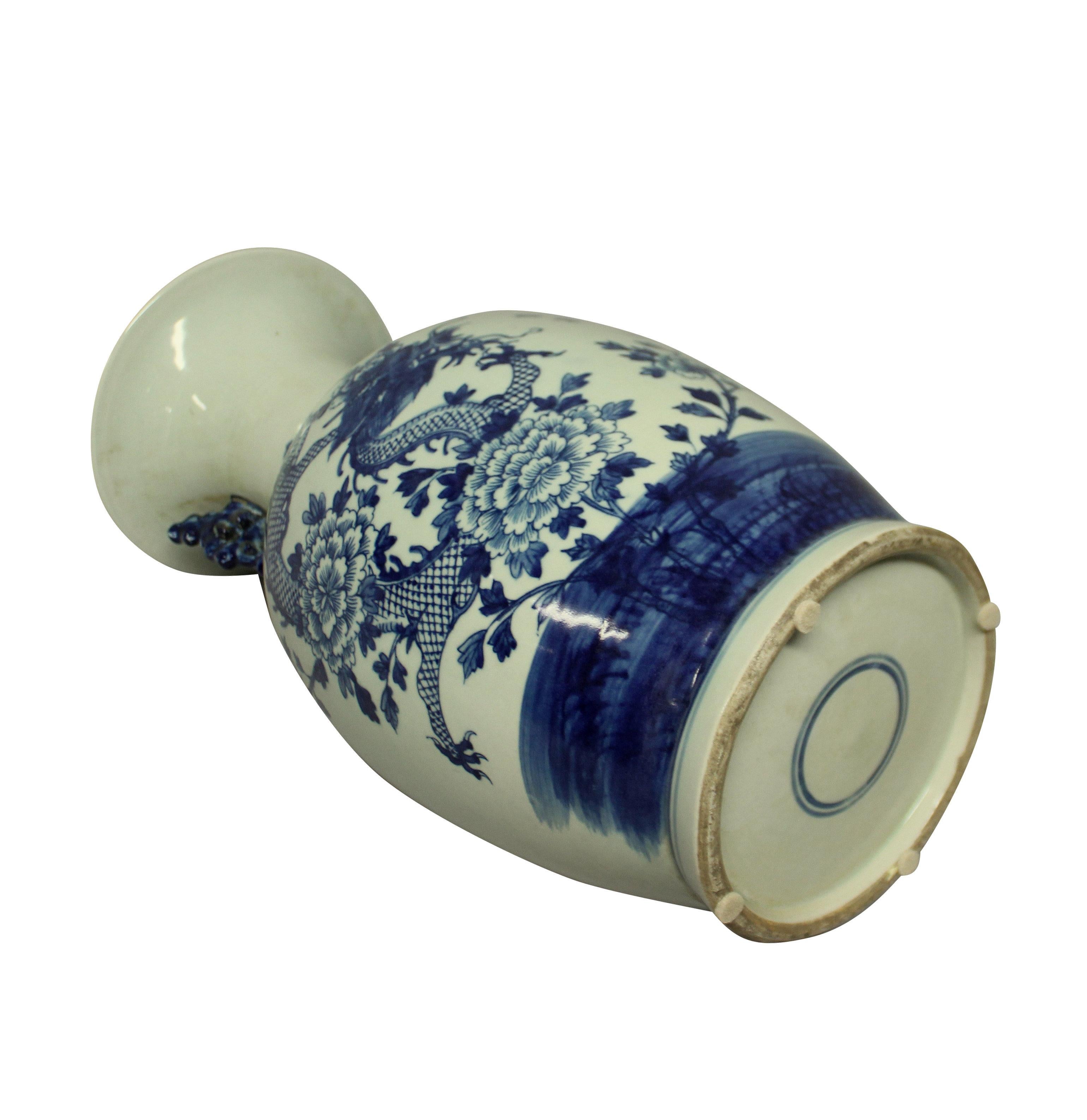 A pair of Chinese blue and white twin handled vases depicting dragons. The background color is a pale duck egg.