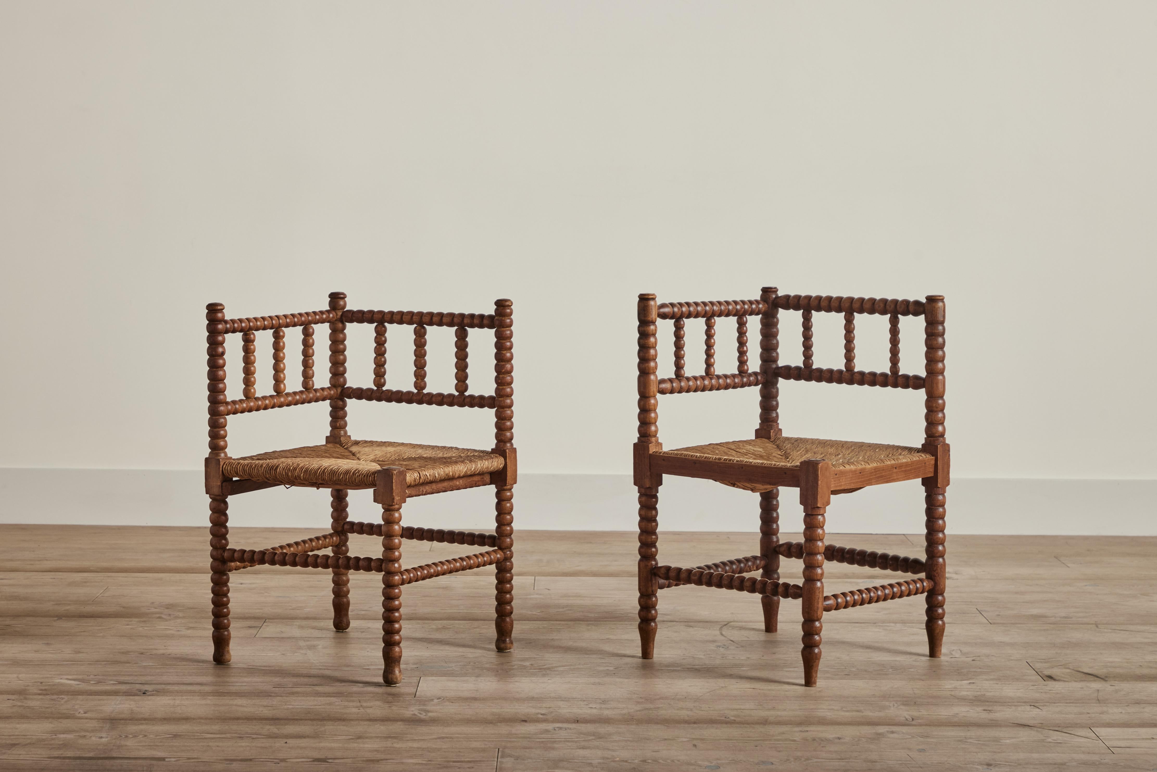 Pair of wood and rush bobbin corner chairs from Denmark circa 1950. Wear on wood and rush is consistent with age and use. 