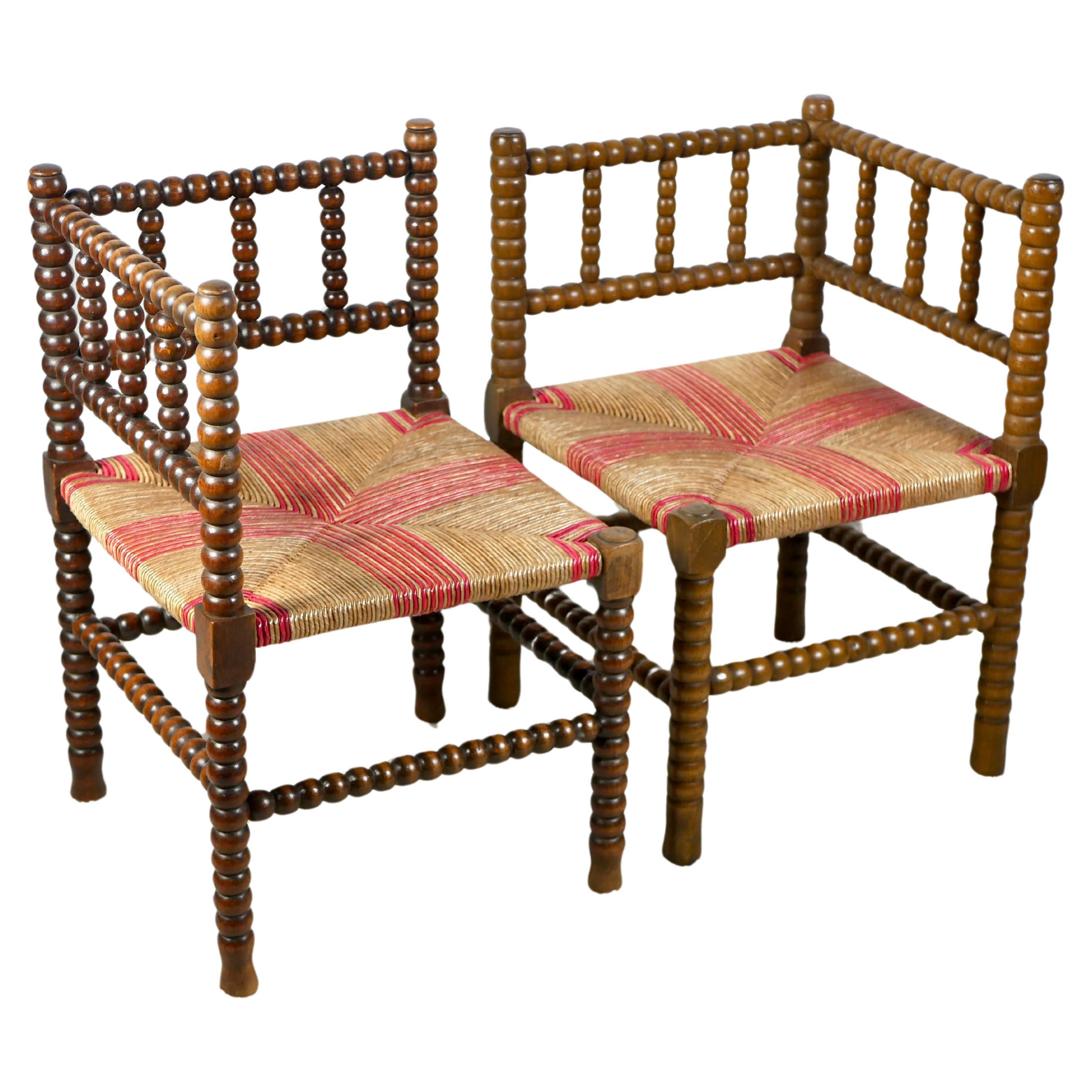 Pair of Bobbin corner chairs, wood and straw, France, early 20th century For Sale