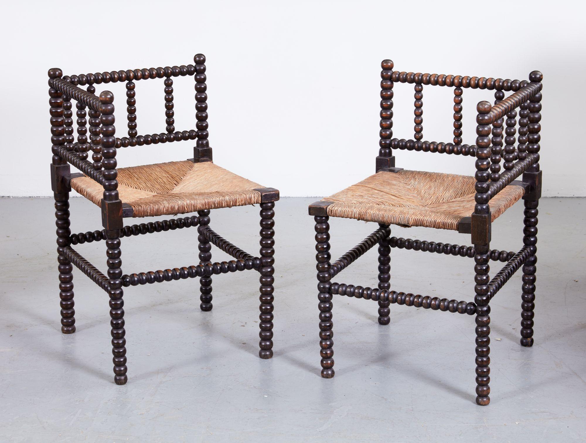 Good pair of English late 19th Century ebonized and bobbin turned corner chairs with woven rush seats.